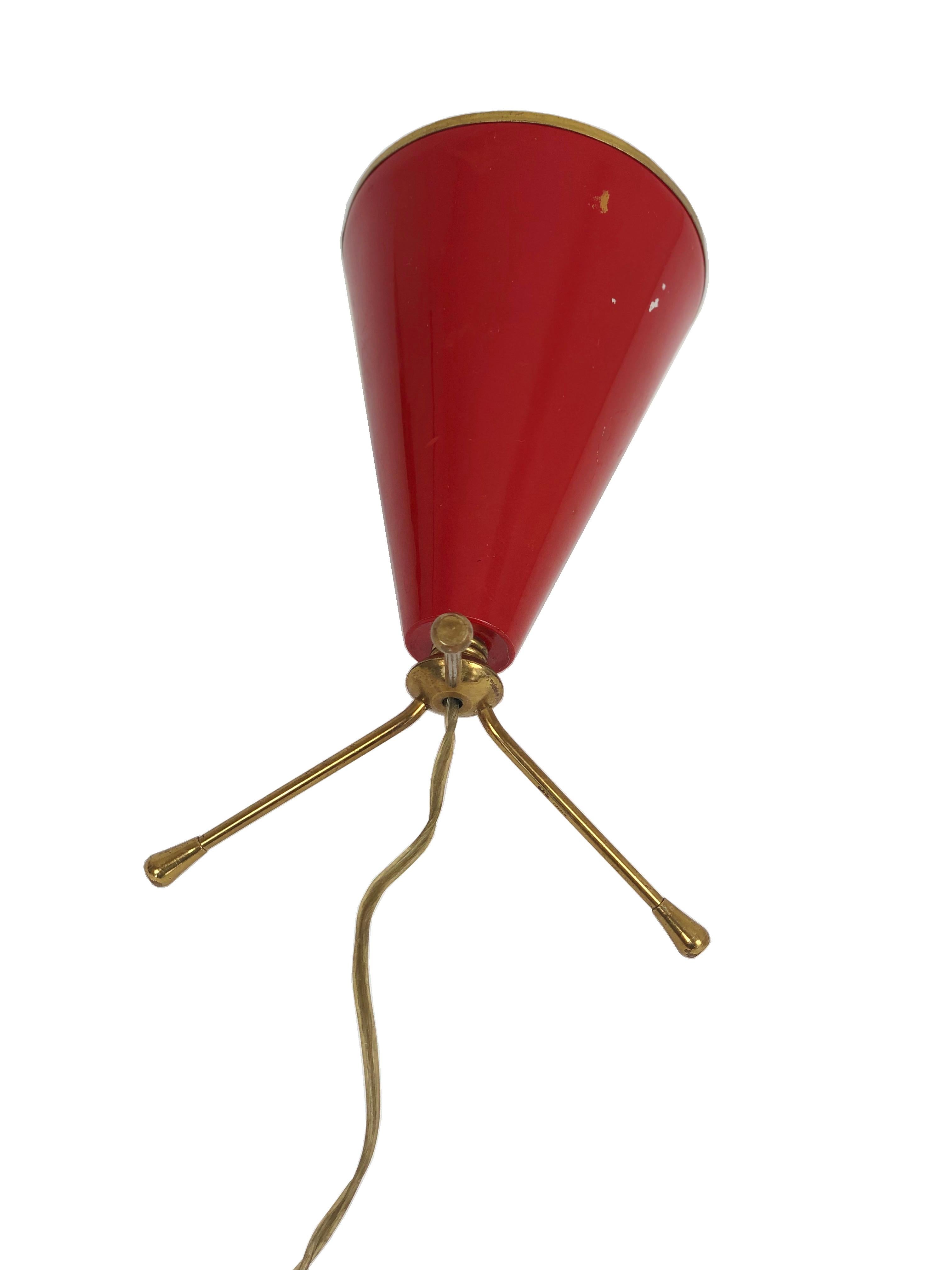 Petite Italian tripod cone shaped table lamp red lacquered metal. Borders and base in brass.
In the style of Stilnovo.