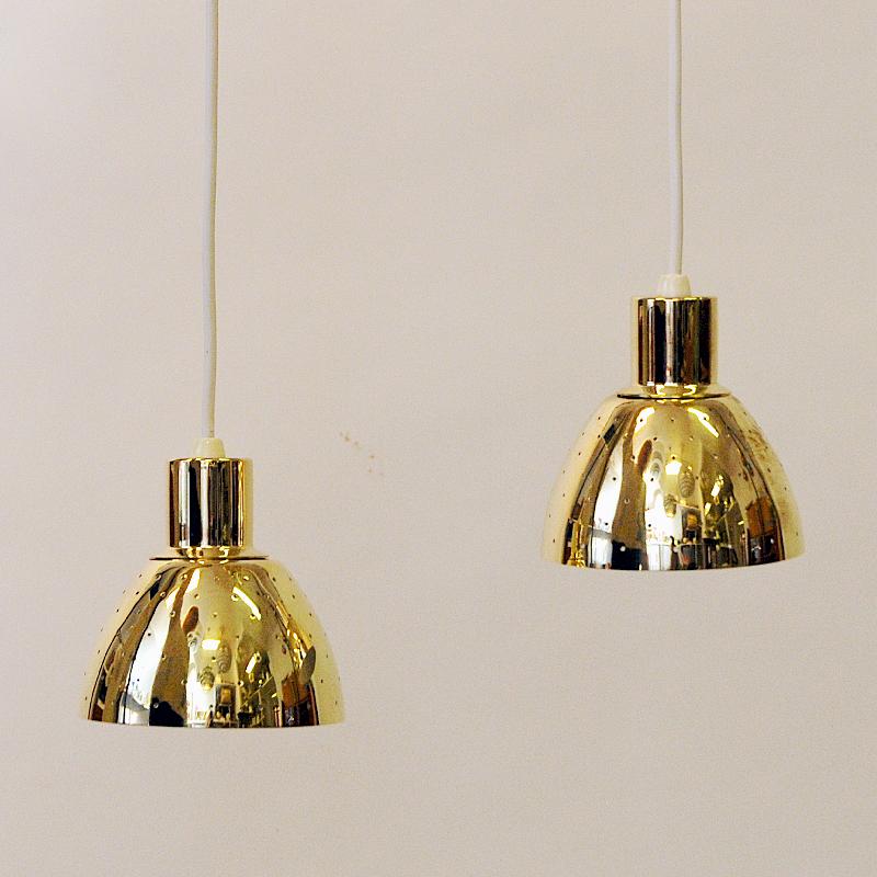 A lovely pair of brass window / ceilinglamps with perforated shades model Flora T618 designed by Hans-Agne Jacobsson for Markaryd Sweden in the 1960s. The lamps are truly beautiful with their ligths lit and can be adjusted to the height or position