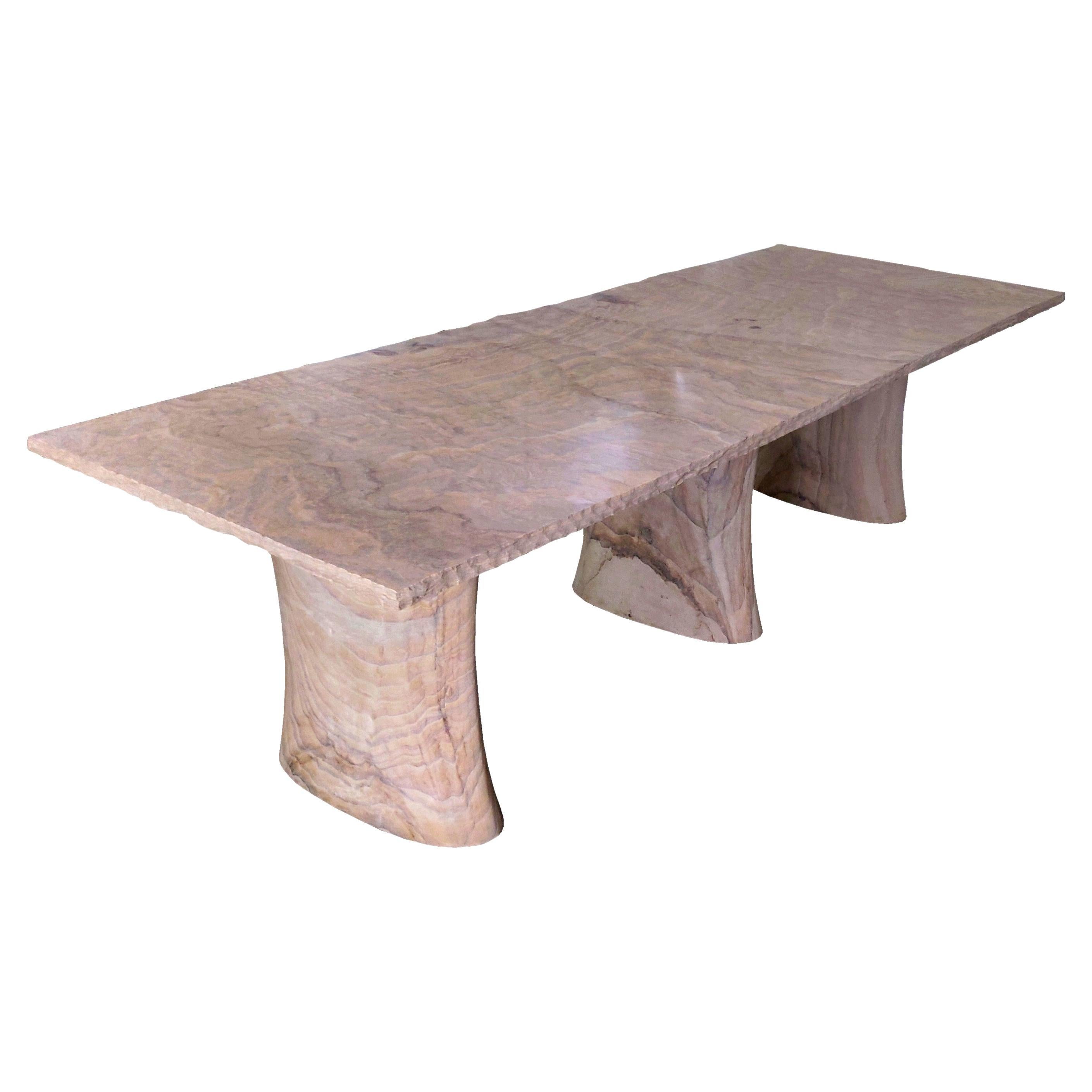 Konferenztisch handgeschnitzt aus Sandstein. Dieser skandinavisch-moderne Konferenztisch von Paul Mathieu wird von Hand aus massiven Blöcken aus Regenbogen-Teakholz-Stein geschnitzt, einem seltenen Sandstein, der die Maserung eines exotischen Holzes