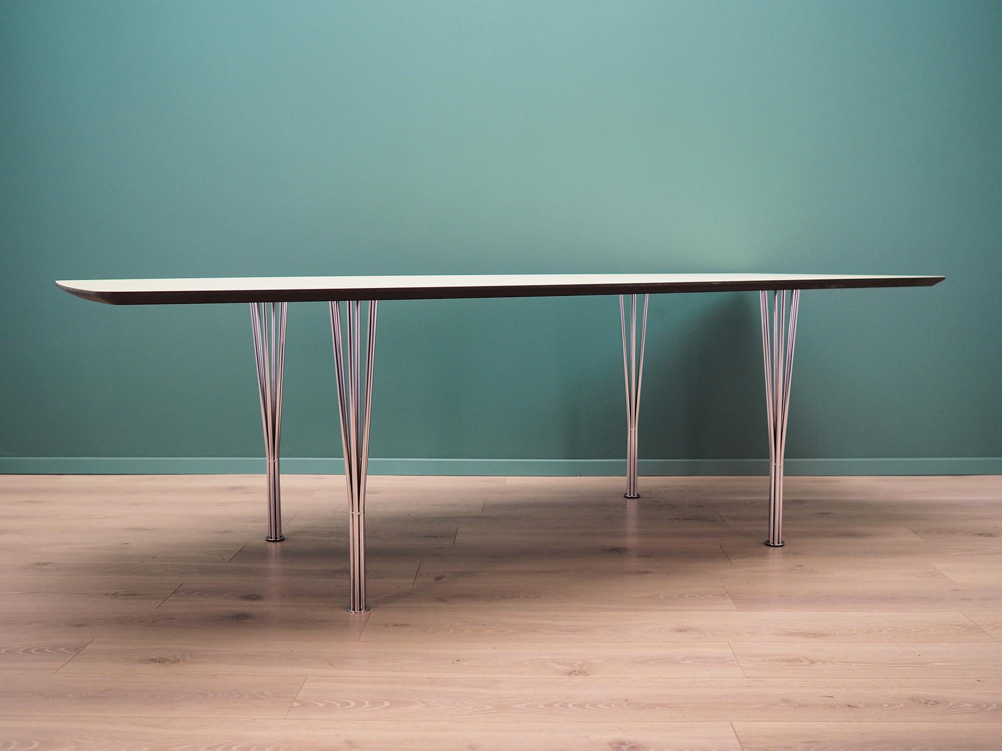 Conference table was made in the 1960s. It was produced by the well-known Danish manufactory Lau Lauritzen.

The tabletop is covered with white high-pressure laminate. The legs are made of chromium plated metal. Surface after