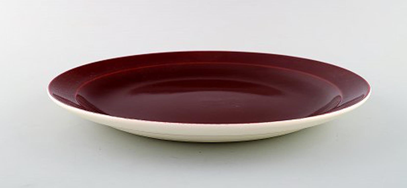 Confetti Royal Copenhagen / Aluminia faience. Dinner/ cover plate in burgundy red, 1940s.
Measuring: 27 cm.
In very good condition.
Stamped.
7 pieces in stock.