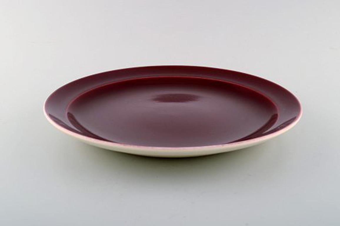 Confetti Royal Copenhagen / Aluminia faience. Dinner/ cover plate in burgundy red, 1940s-1950s.
Measuring: 27 cm.
In very good condition.
Stamped.
7 pieces in stock.