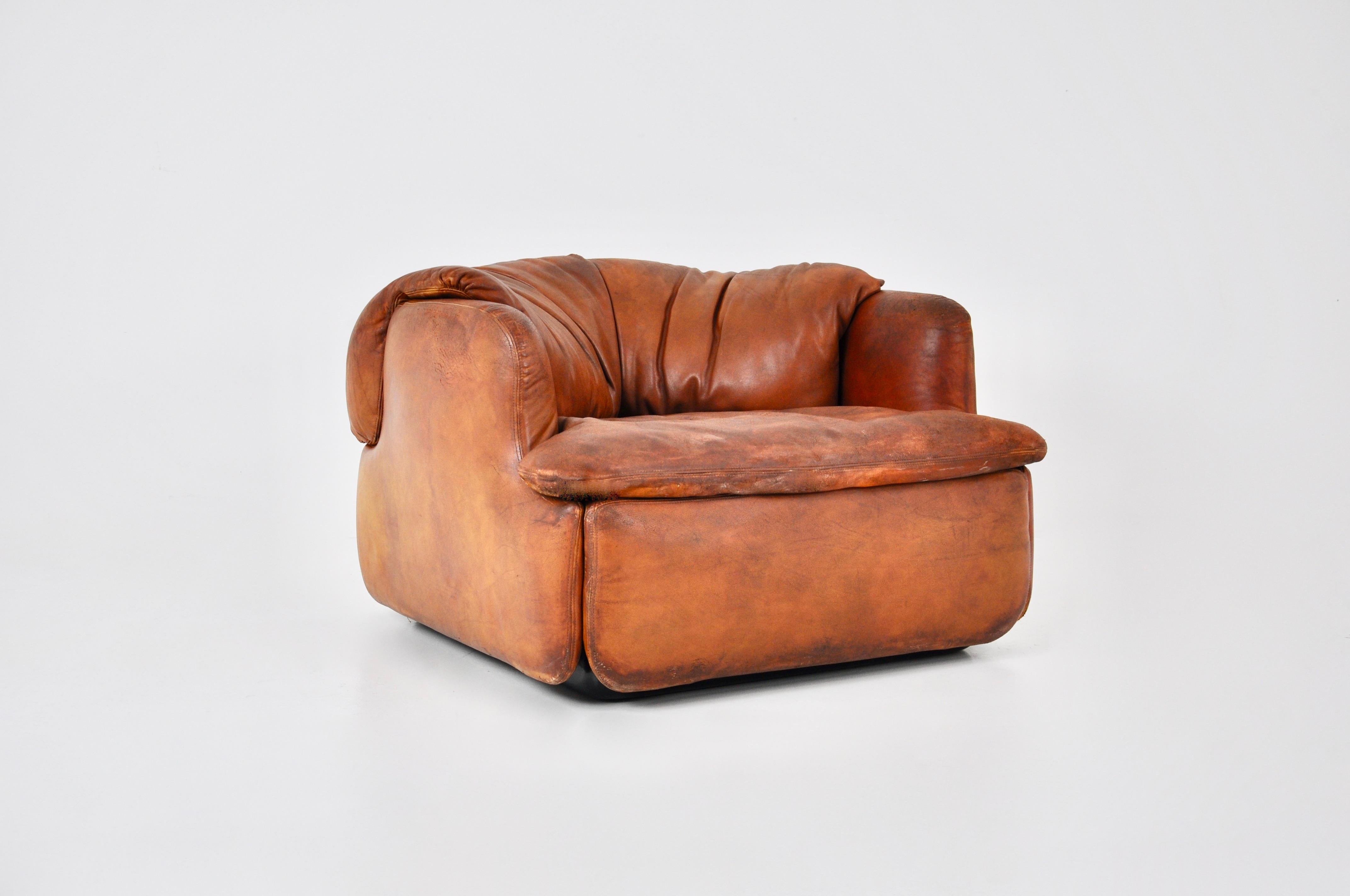 Cognac leather armchair with plastic feet. Stamped Saporiti. Seat height 36cm. Wear due to time and age of the sofa.
 