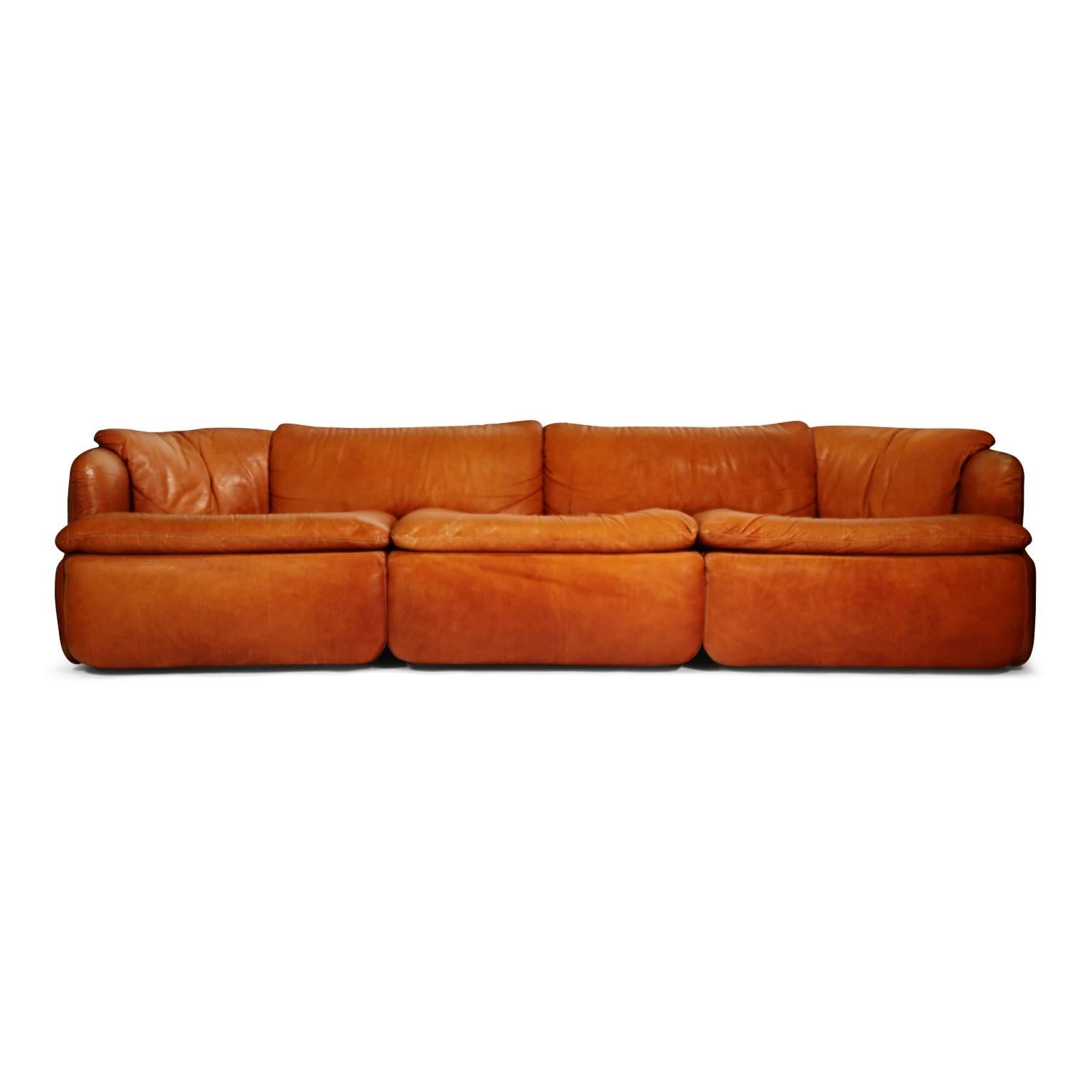 A beautiful 'Confidential' three-seat sofa by Alberto Roselli for Saporiti Italia in gorgeous distressed cognac colored leather. 

This rare and on-trend designer sofa was designed in the 1972 by the Italian architect, Alberto Rosselli. Incredible