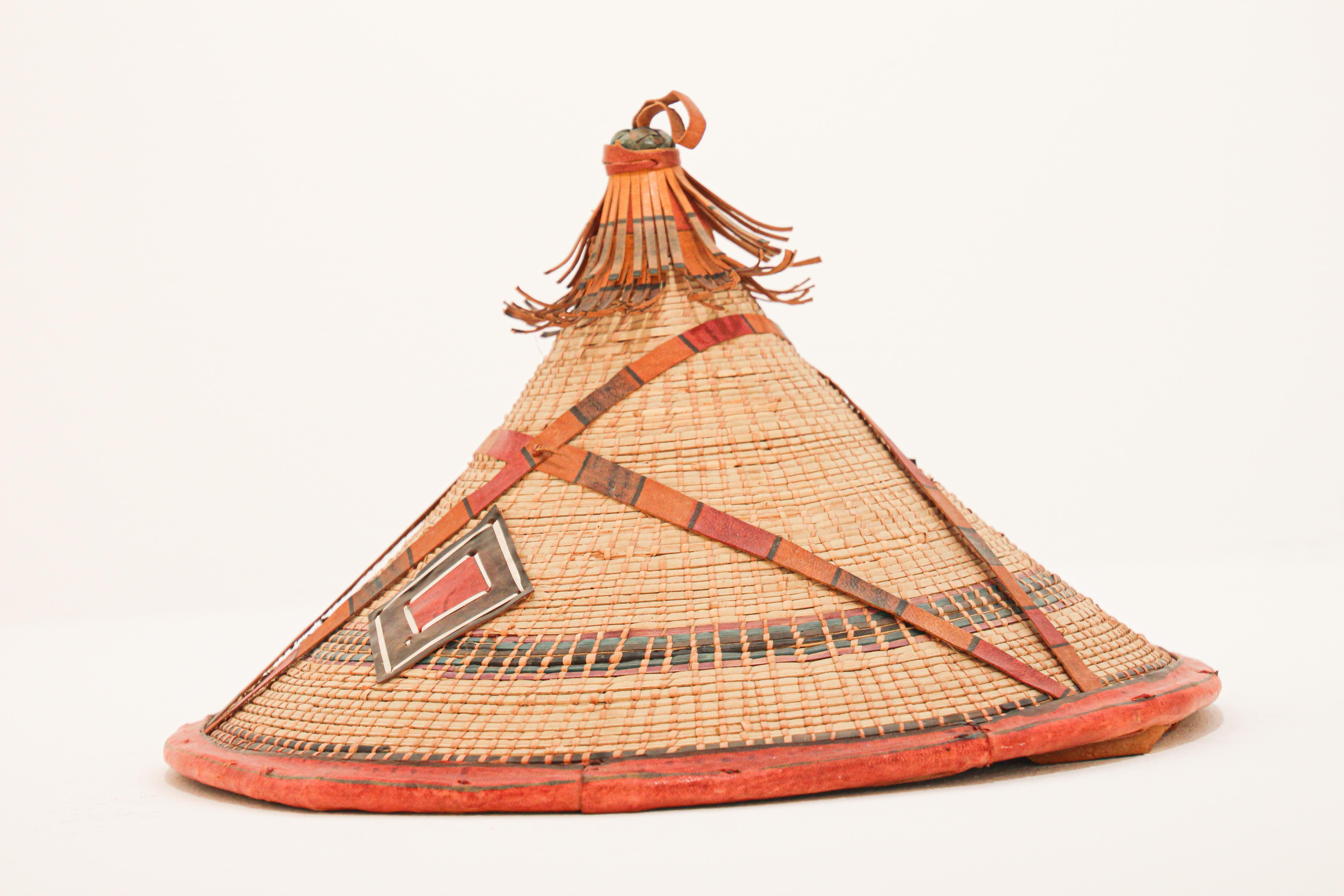 Conical leather and straw tribal Fulani hat, Mali West Africa
Folk Art organic fiber hat with leather applications that comes from the Fulani people in West Africa.
It is typically worn by the Wodaabe, a nomadic cattle-herder subgroup of the