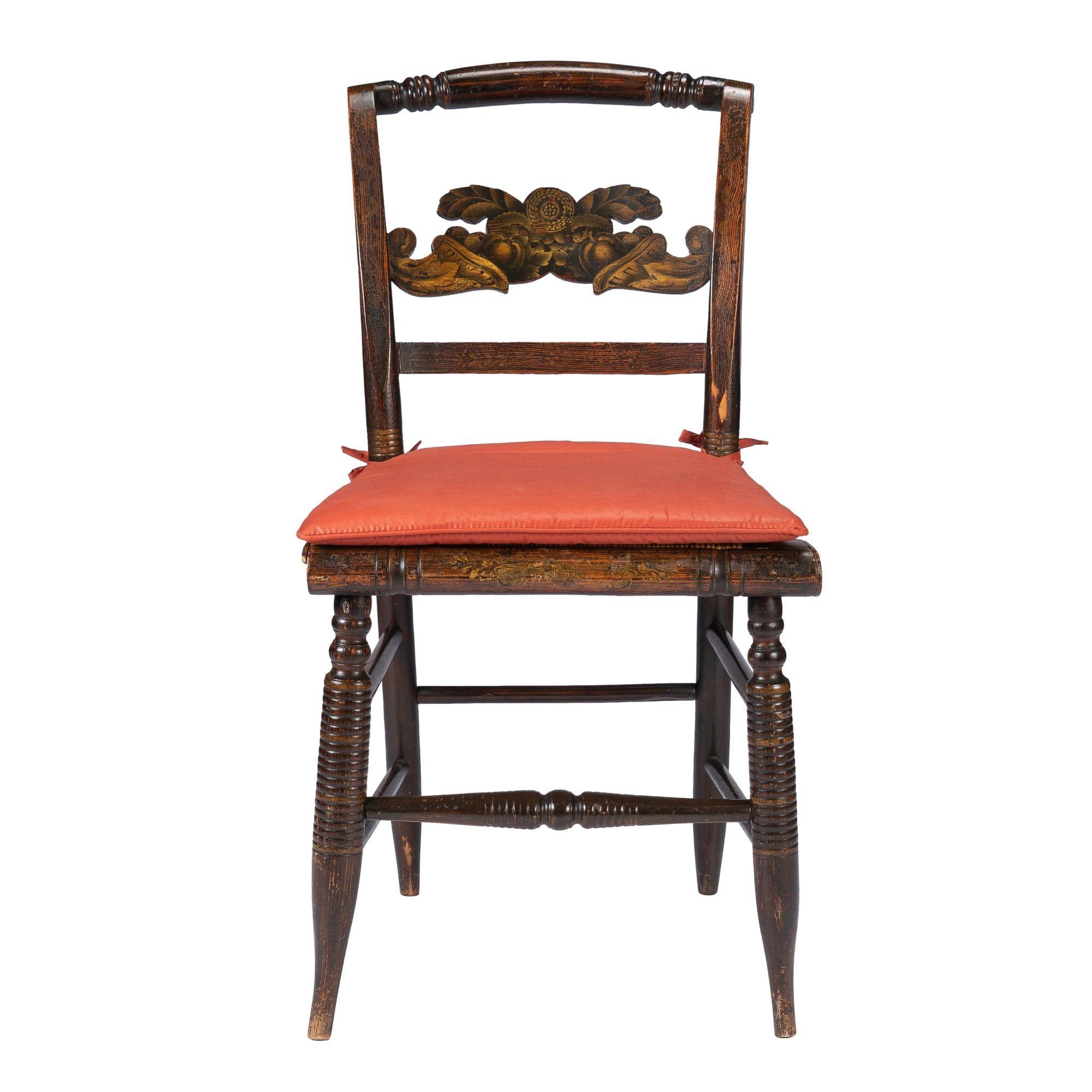 American Hitchcock rush seat side chair with a tie-on seat cushion. The chair features the original gilt and bronze powder stencil decoration on the double cornucopia back splat as well as a faded floral motif on the front seat rail. The rush seat