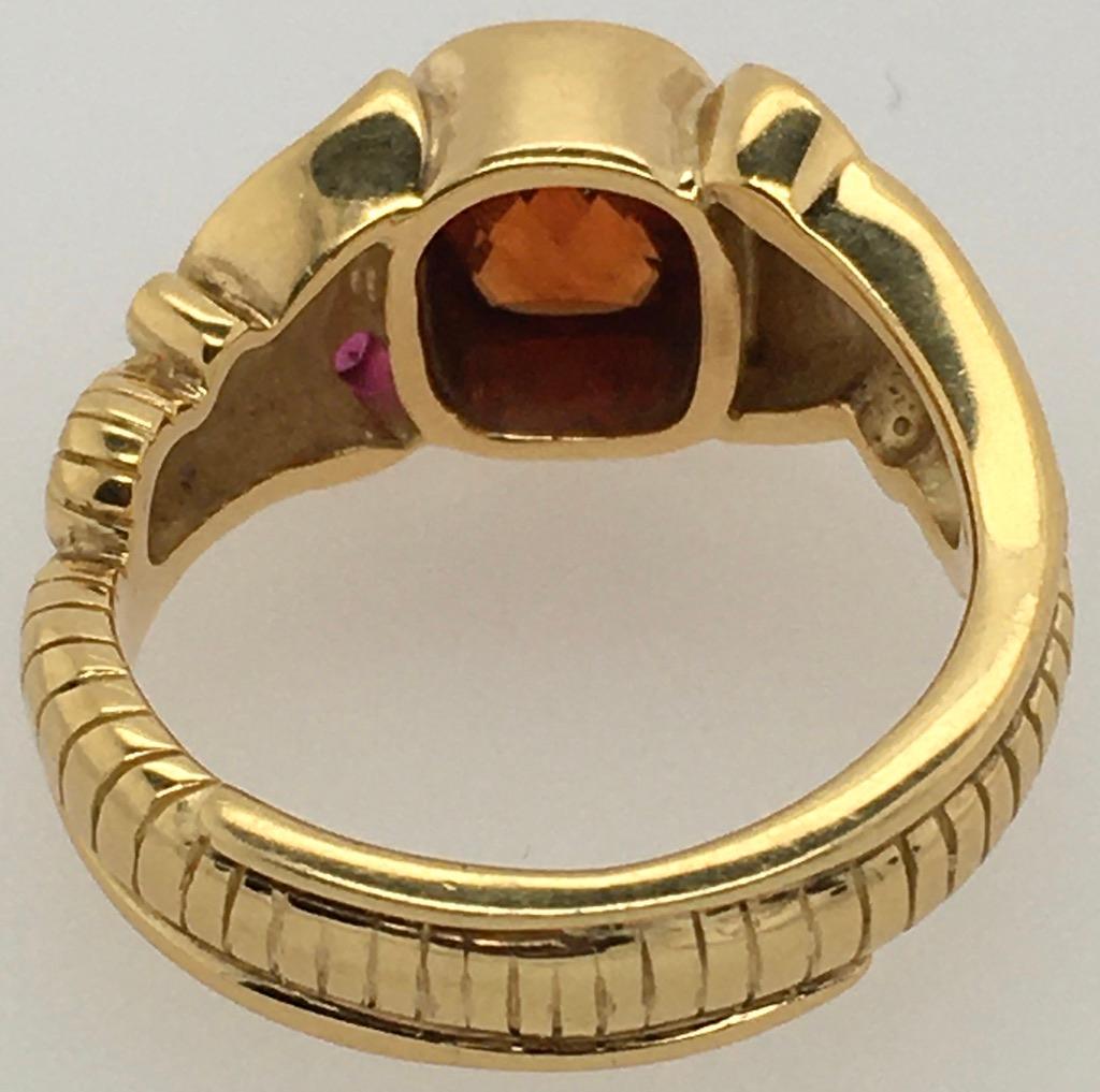 This intricate 18K gold leaf and fern ring is set with a dramatic cushion-cut Spessartite garnet  and two round pink sapphires. The garnet is fiery red with orange tints; the 2 sapphires are dark pink. Style is R623-20.  The ring is size 6.5.