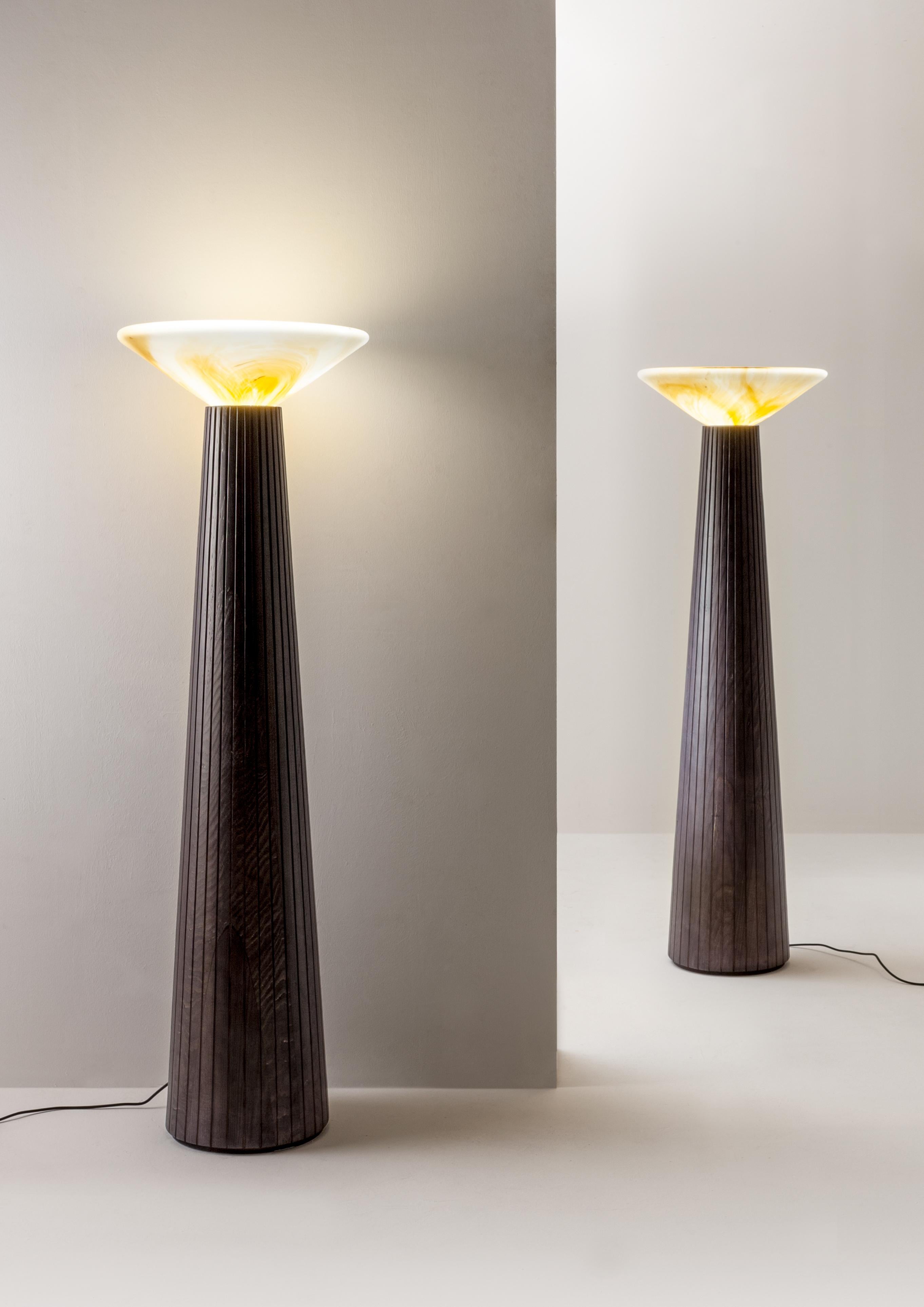 Lámpara de pie Cono da Terra de Laurameroni
Dimensiones: An 50 x Pr 50 x Al 170 cm
Materiales: Pantalla de cristal de Murano y estructura de madera maciza negra. 

Lámpara de pie formada por una sólida estructura de madera de abeto teñida y una