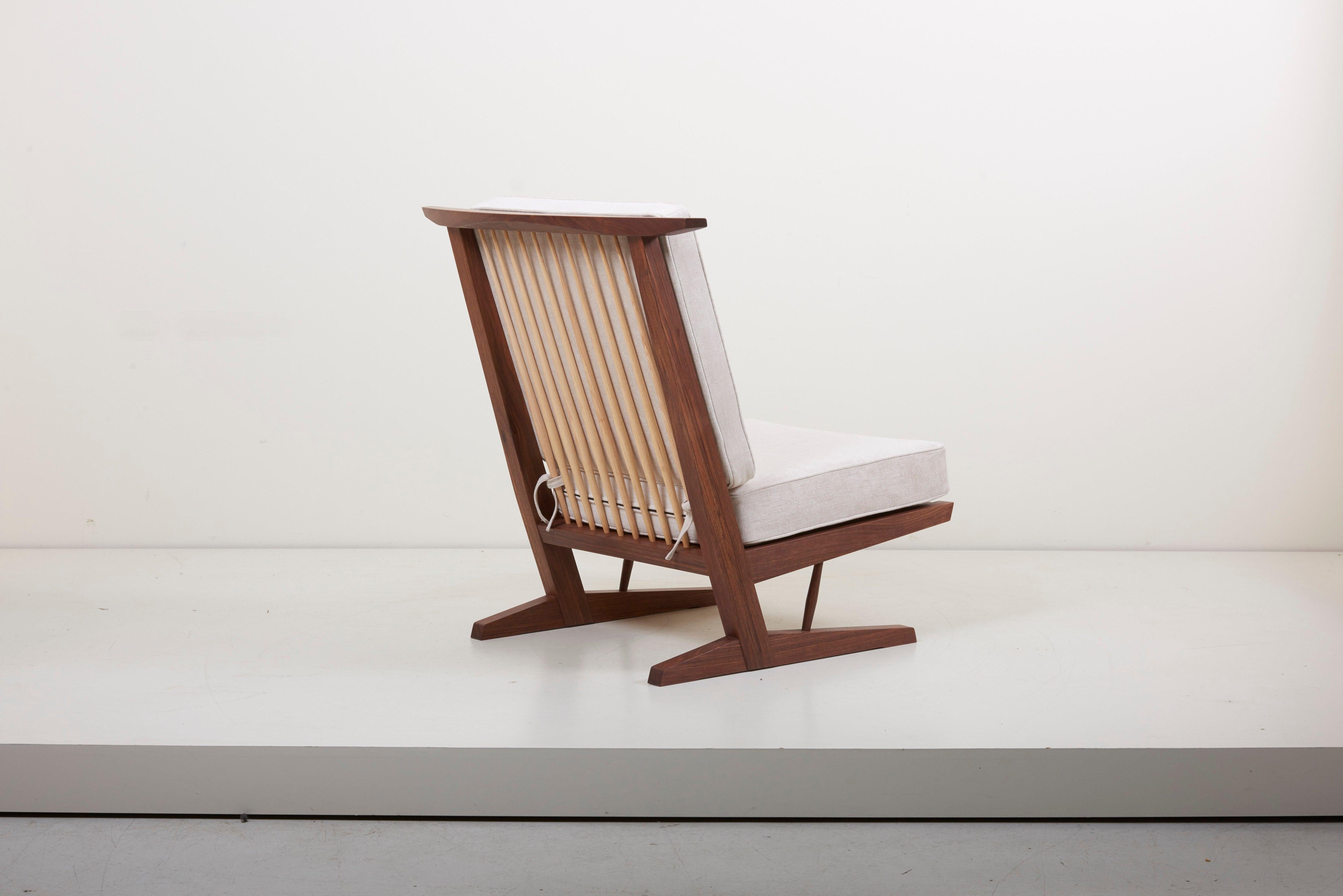 Conoid lounge chair in American black walnut with hickory spindles by Mira Nakashima. Based on a design by George Nakashima.

Newly upholstered in Mark Alexander fabric. Production Lead time is around 18 months.