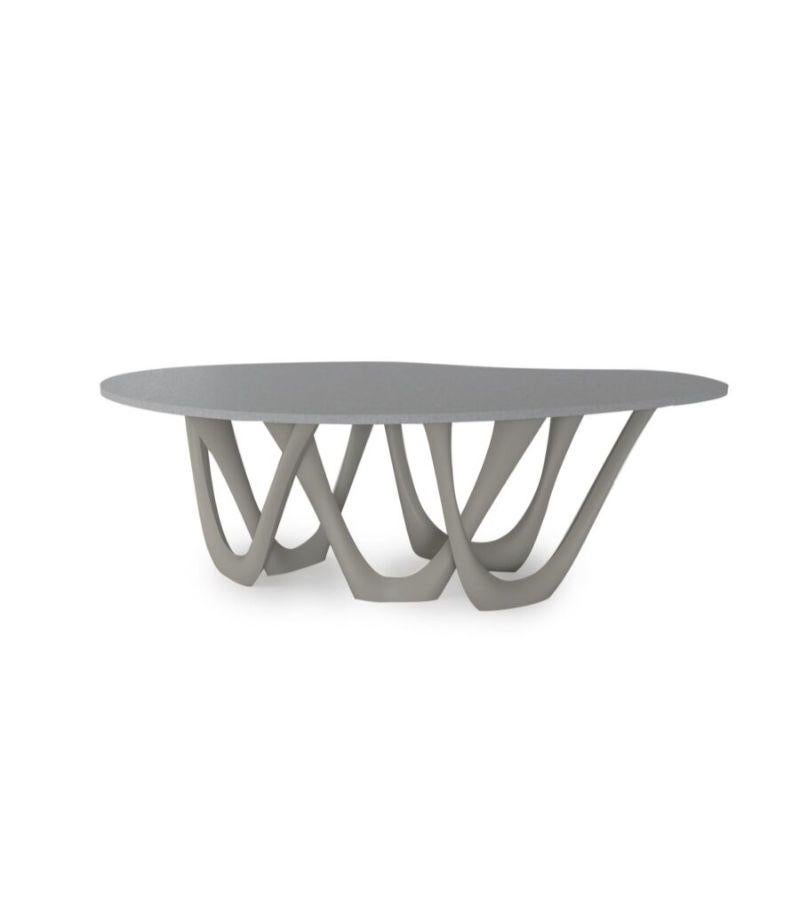 Table en acier gris béton g-table de Zieta
Dimensions : D 110 x L 220 x H 75 cm 
Matériau : Plateau en béton. Base en acier au carbone. 
Finition : Revêtement en poudre.
Disponible en couleurs : beige, noir/marron, noir brillant, bleu-gris, gris