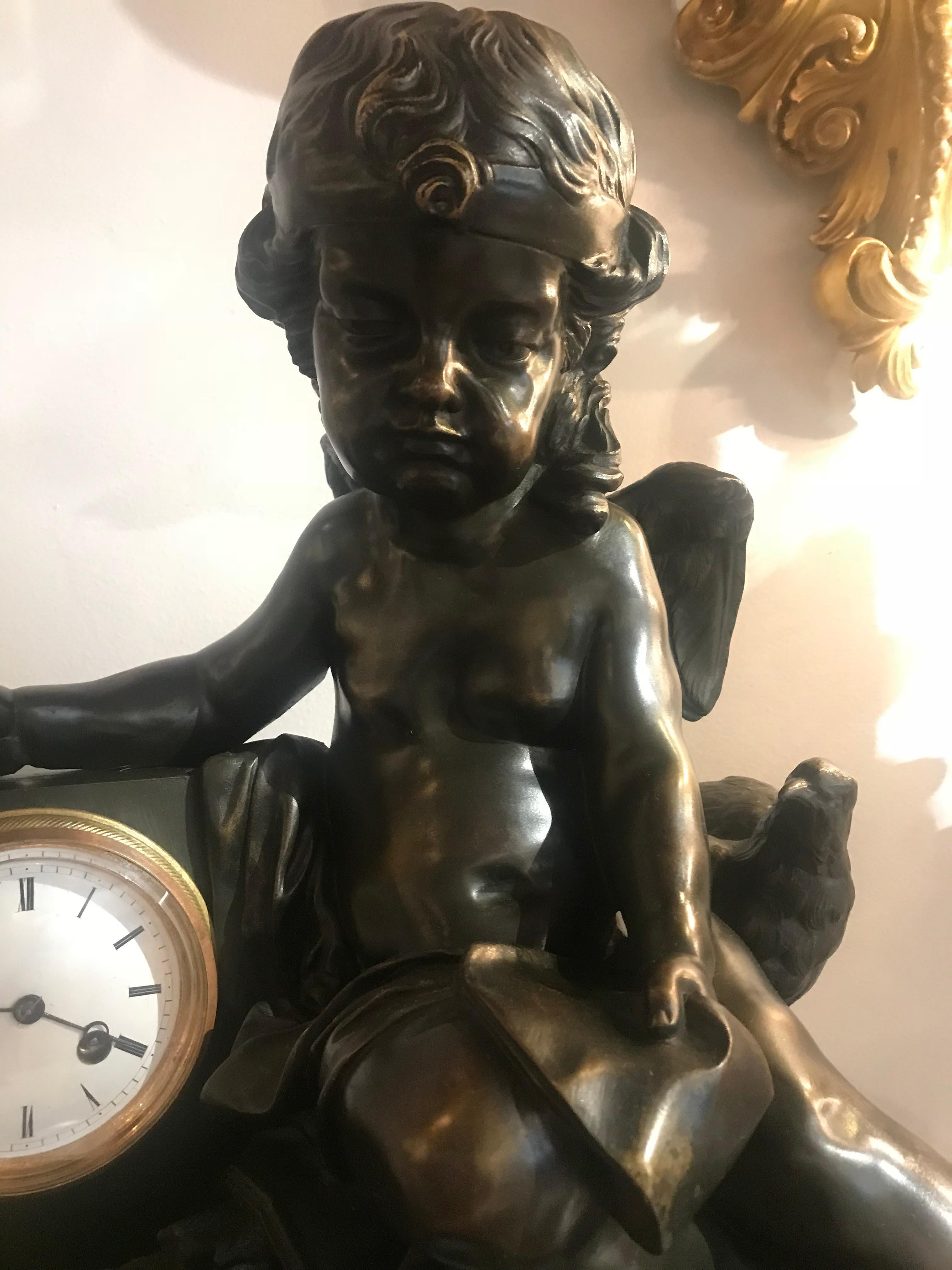 A magnificent bronze clock depicting a resting Cupid with his quiver and bow and a dove as messenger of love. The whole raised on Rouge Griotte marble plinth enriched with gilt and matte bronze banding. 
France, circa 1880

Dimensions: 
H 21.75