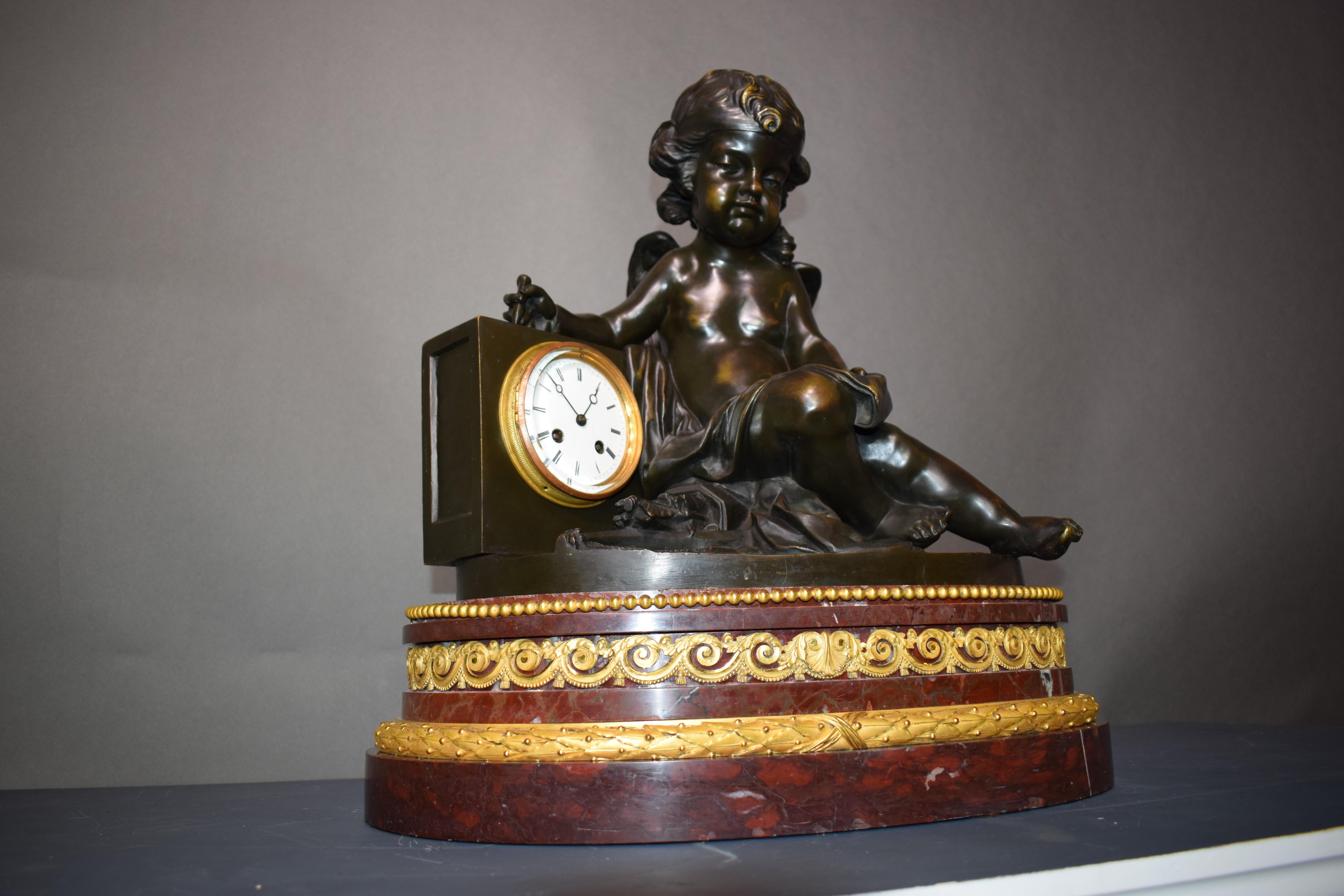 19th Century A magnificent bronze clock depicting a resting Cupid For Sale