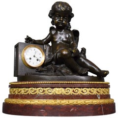 A magnificent bronze clock depicting a resting Cupid