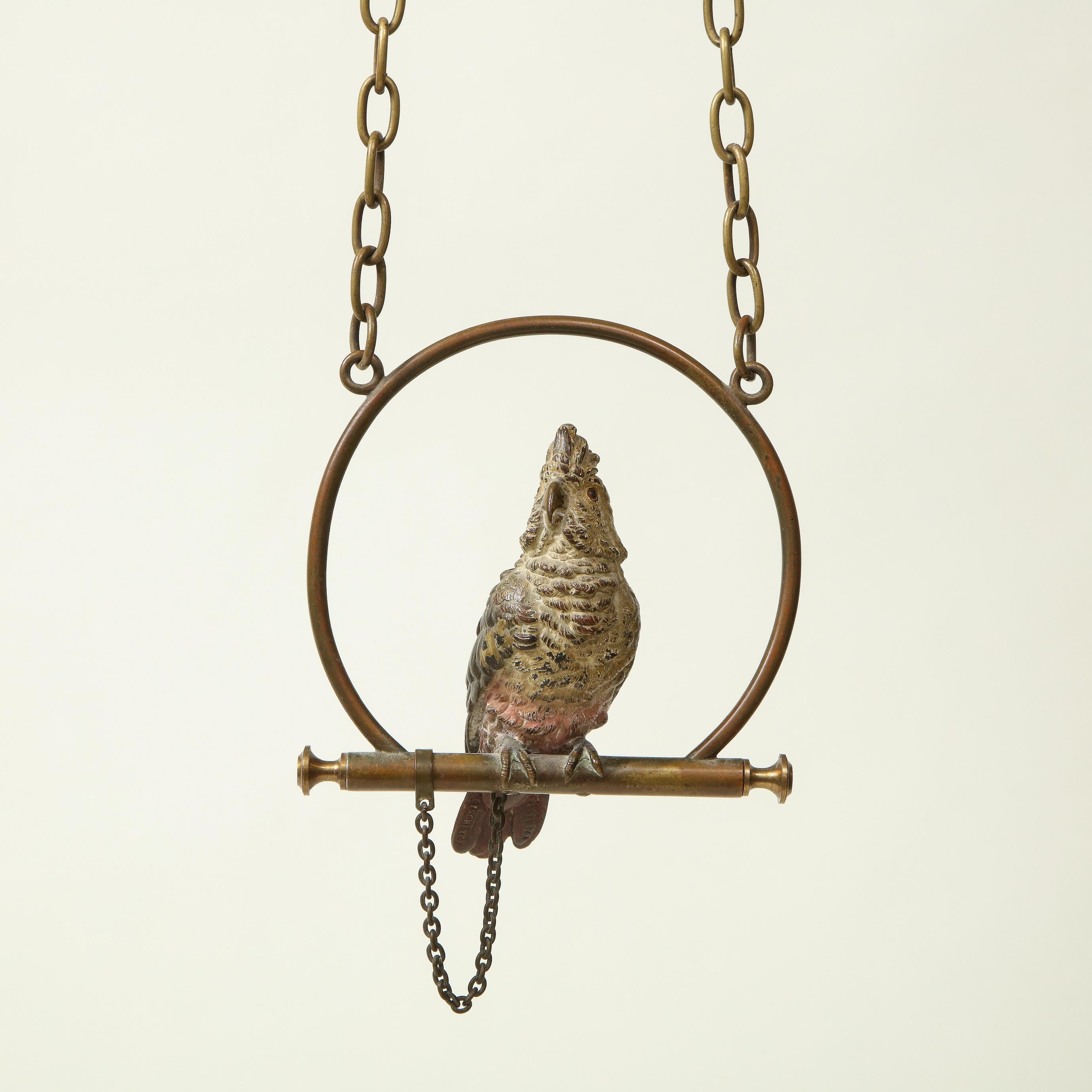 With white, blue, and red plumage; chained to metal perch. 

Provenance: From the Collection of Mario Buatta, New York, NY.