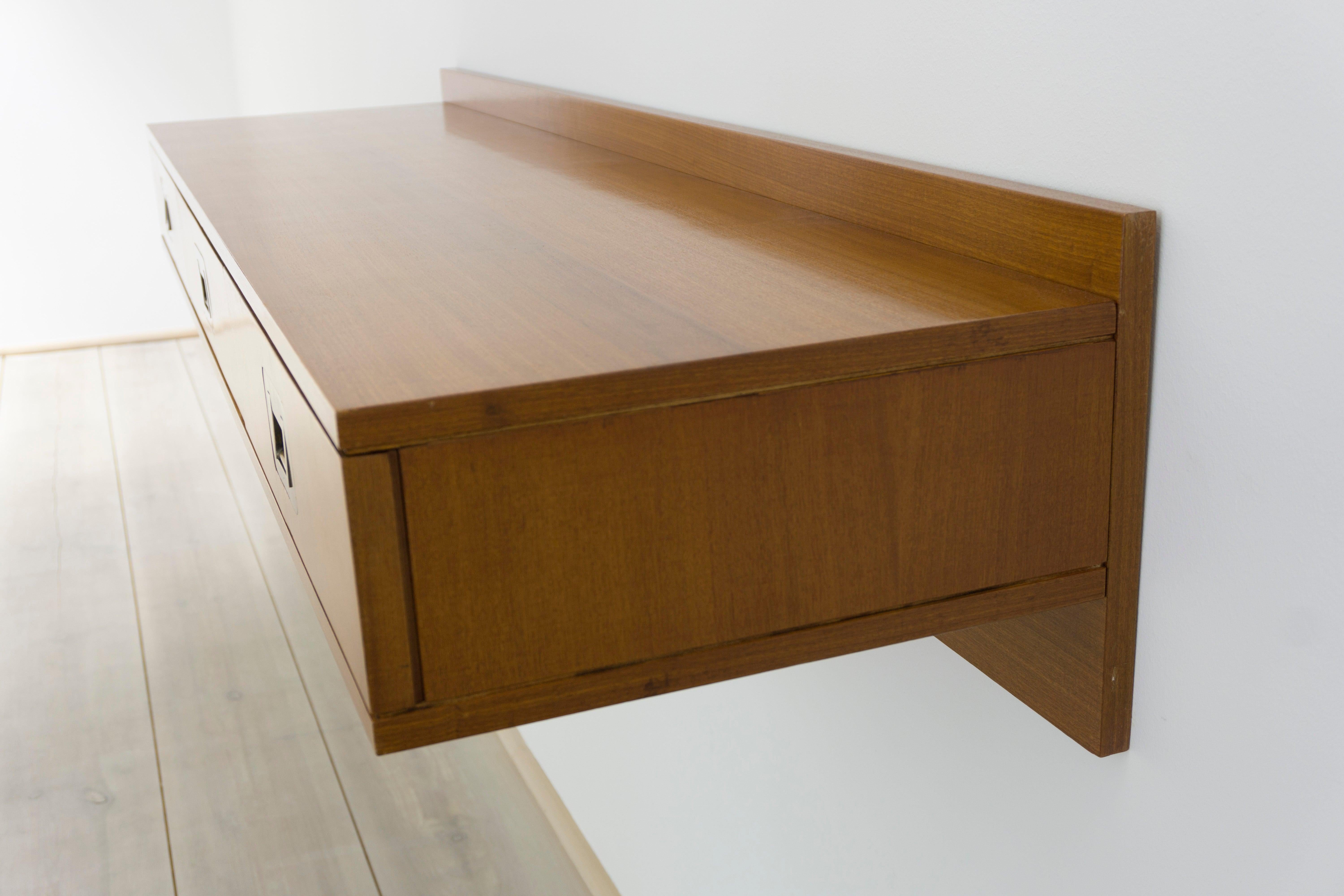 Console for wall, made of walnut with brass handles. Three drawers. 

Dimensions / H.16/30cm - W.150.5cm - D.41cm 
Design / Ico Parisi 1958 
Manufacturer / Colombo e Clerci Como / Brugnoli Mobile Cantú 1960 cf. Roberta Lietti, Ico Parisi,