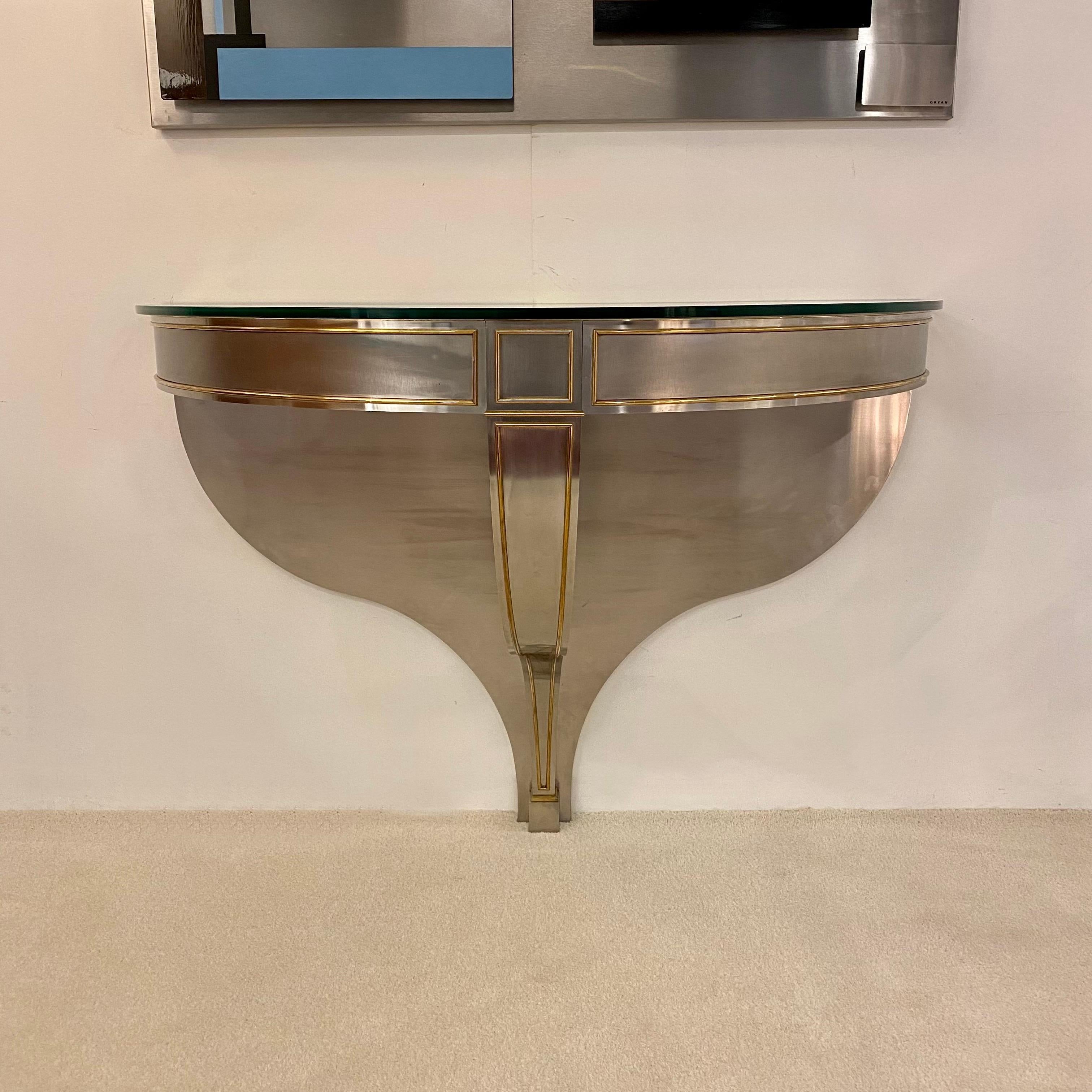 Stainless steel and brass plated console with glass top.Console in the Louis XVI Style made by Maison Jansen,France 1970’s.