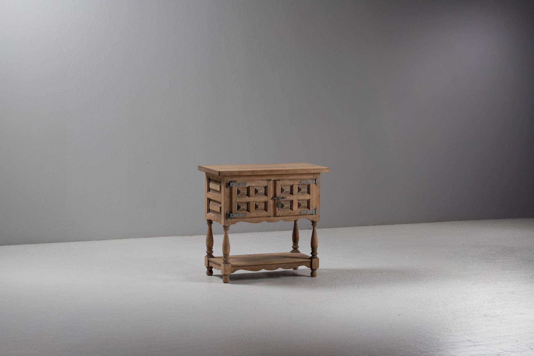 With a tactile geometry and restrained rusticity, this Spanish cabinet evokes the poetic architecture of Iberian vernacular design. Its façade, framed in solid elm, is composed of repeating recessed panels, their sculptural rhythm softened by the