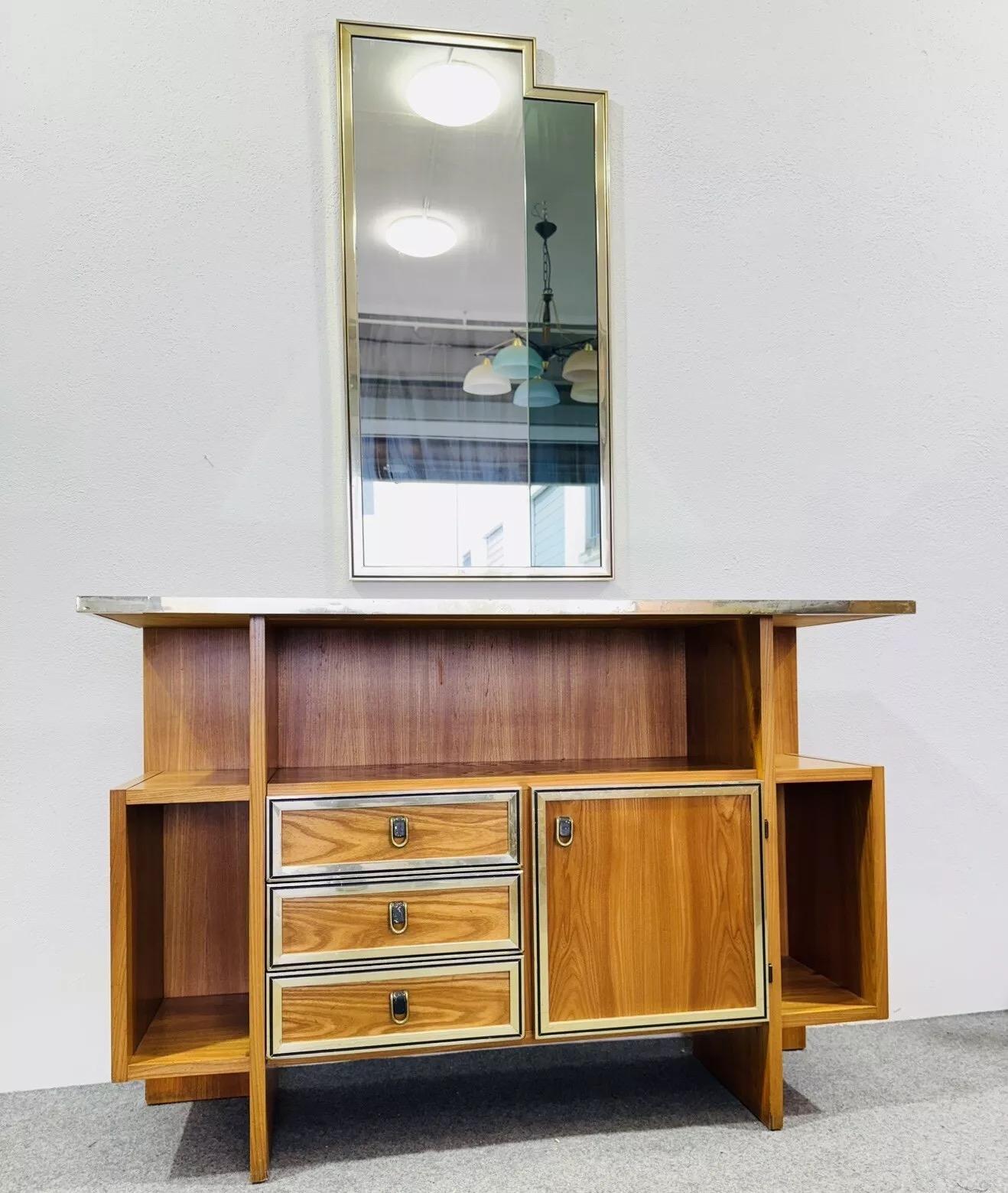Console With Mirror Design 1960's Modernism.

All-wood frame, brass handles, golden metal details and profile, mirrored glass console top.Geometric design mirror with double glass (smoked/transparent) and golden metal frame.

The item is in good