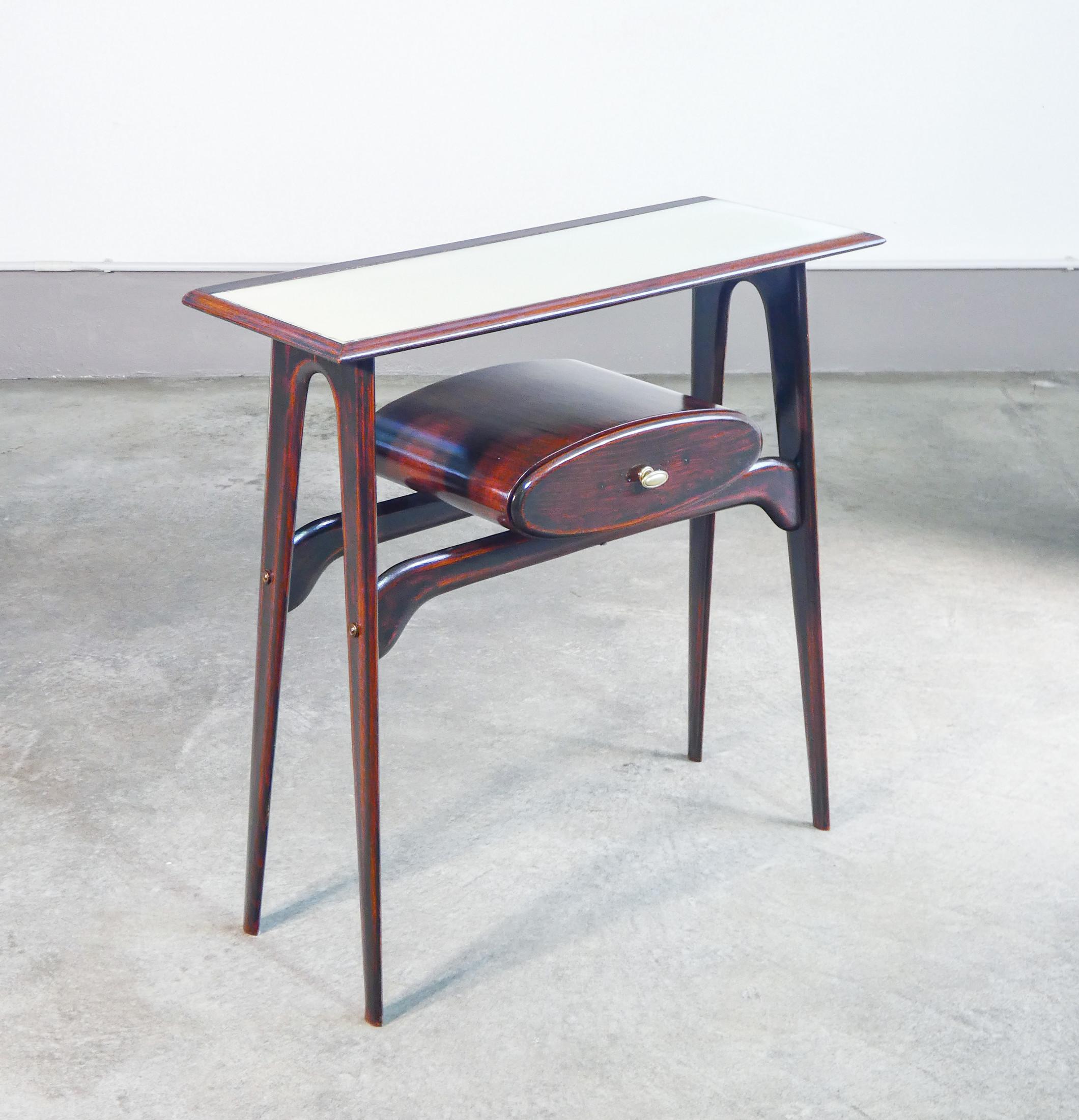 Console, design
Ignazio GARDELLA
in legno, cassetto
e piano in vetro.

ORIGINE
Italia

PERIODO
Anni 50

DESIGNER
Ignazio GARDELLA (1905-1999) è stato uno dei protagonisti del razionalismo e dell’architettura italiana del Novecento. Nato a Milano in