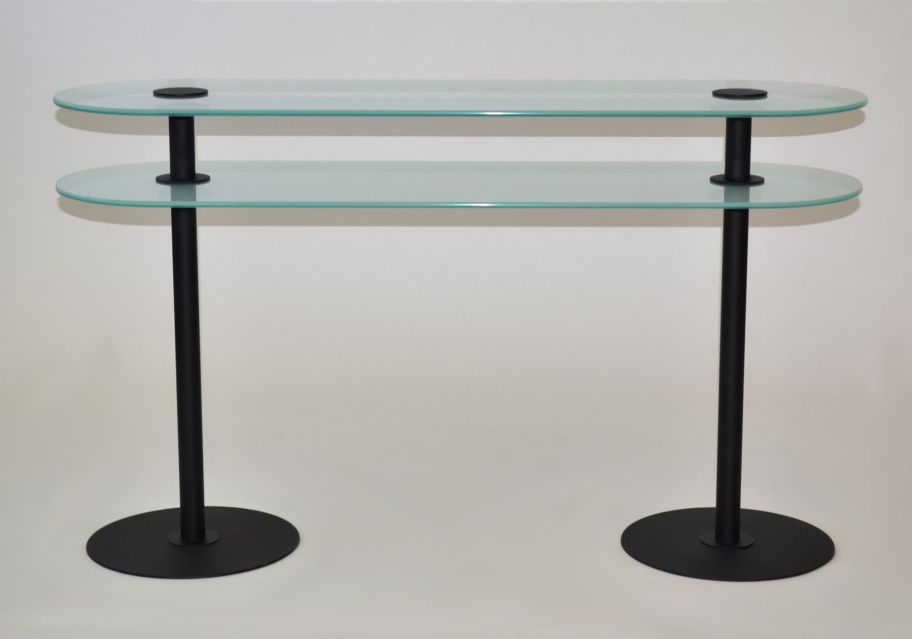 Post Modern Console Table, Italy 1980s
Console, Entry or Hall Table in Sand Blasted Glass with Black Enamel Legs - Post Modern sleek design.
Capsule-shaped top and shelf of thick light green-tinted sandblasted glass. Black enameled legs, caps and