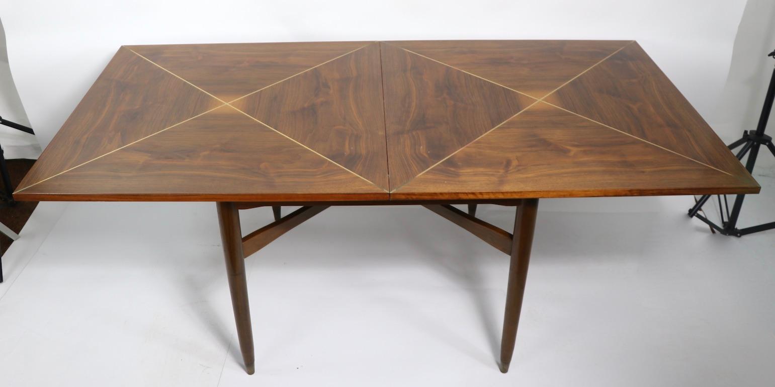 Rare flip top dining table, designed by Tommi Parzinger for Parzinger originals, circa 1950s. Stunning diamond pattern veneer, with elegant architectural brass X form string inlay. This example is in very fine, original, untouched condition, showing