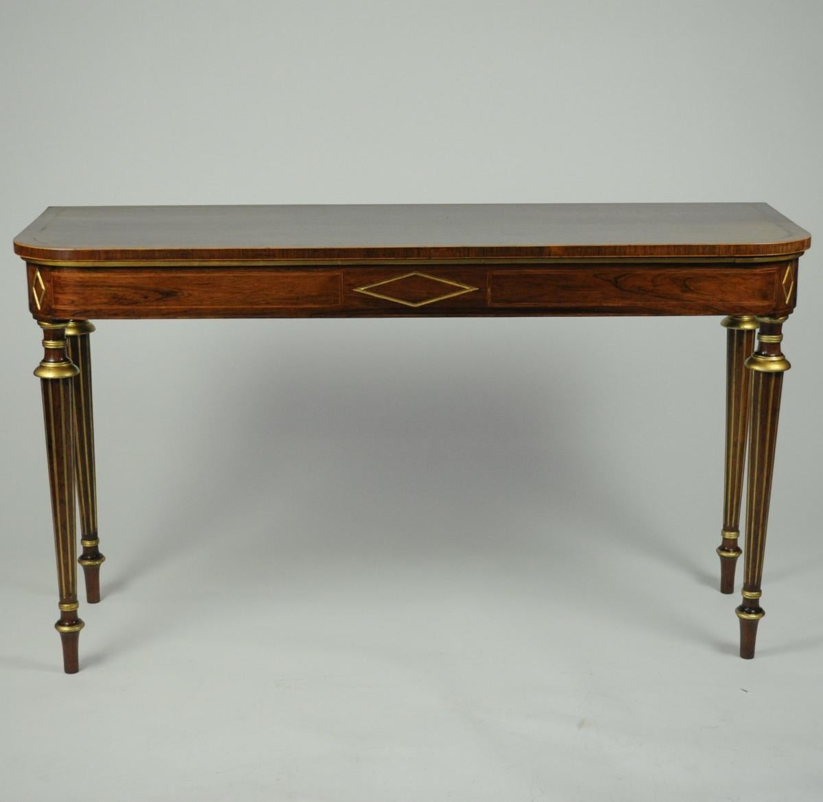 CONSOLA / HALL / MESA AUXILIAR A LA MANERA DE HENRY HOLLAND

Alrededor de 1800
Palo de rosa
Excepcional y rara mesa auxiliar de palisandro y parcela dorada de la Regencia, a la manera de Henry Holland. La parte superior tiene bandas cruzadas con