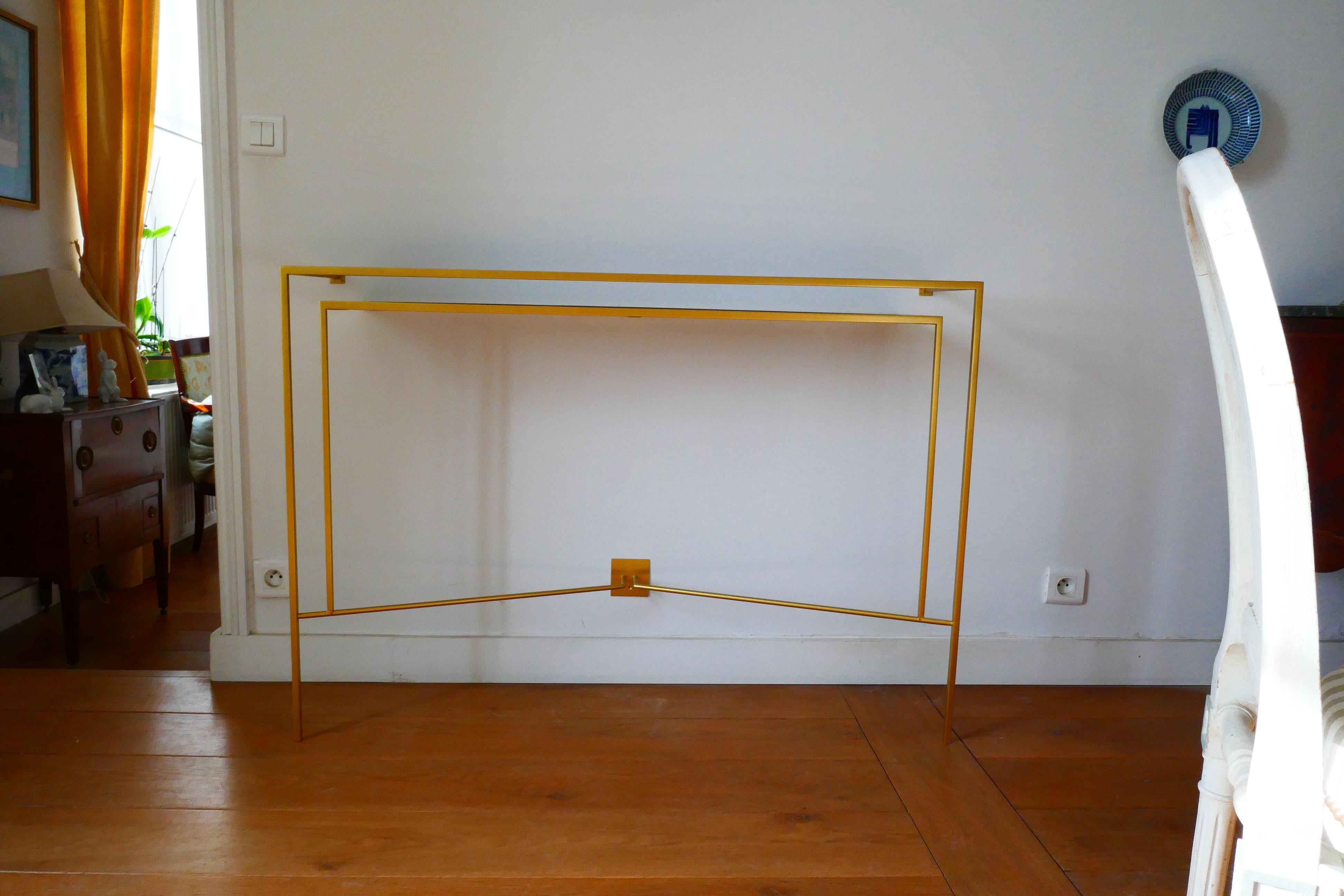 Estructuras de metal patinado dorado con estante de madera de nogal.
Fijación con tornillos ocultos una vez colocada la estantería, dos tornillos en los cuadraditos uno a la banda superior y un tornillo en la banda inferior.
Esta pieza está