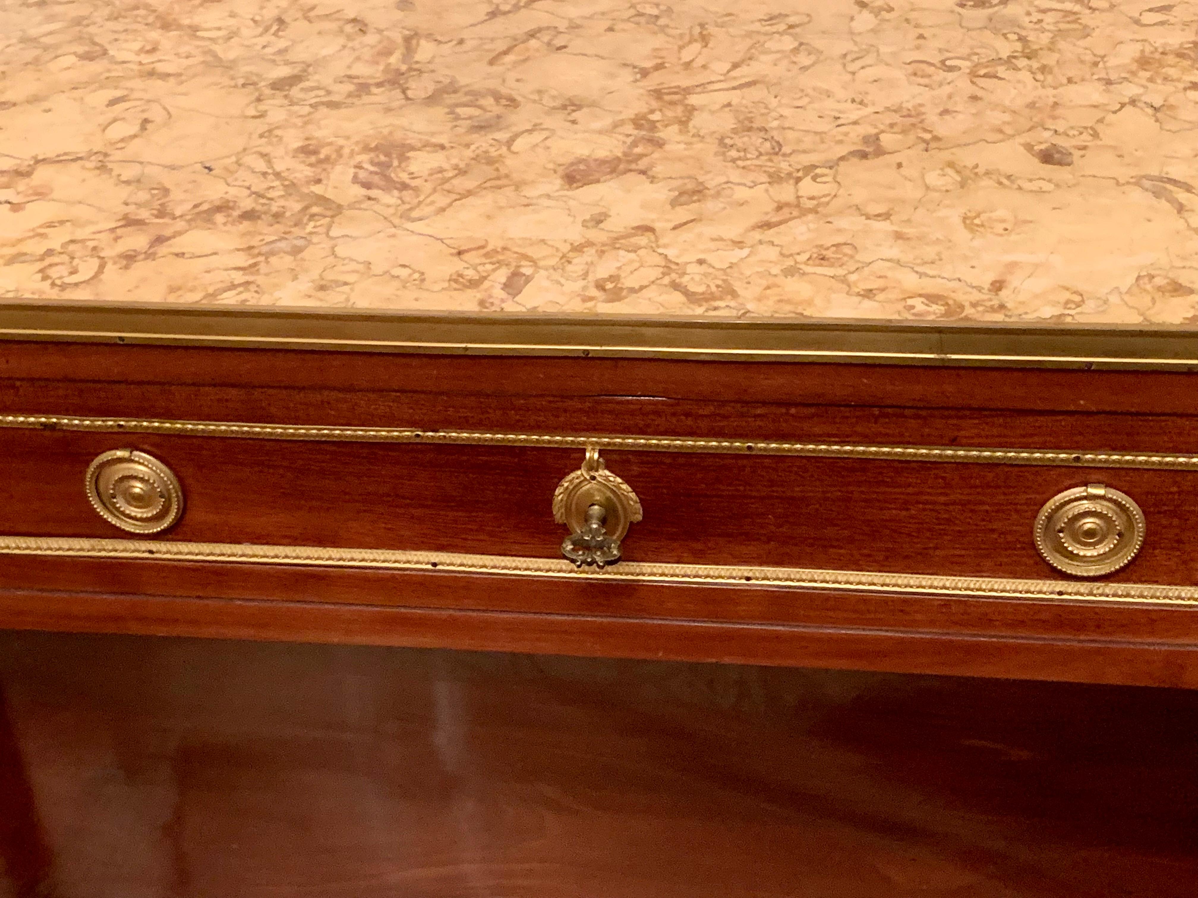 Console molto bella in mogano e bronzo  con un distanziatore sostenuto da quattro piedi con asparagi in mogano sul fondo dei piedi e finitura con sabot incassati, con tre cassetti in cintura, il piano con un marmo incassato da una cintura in bronzo