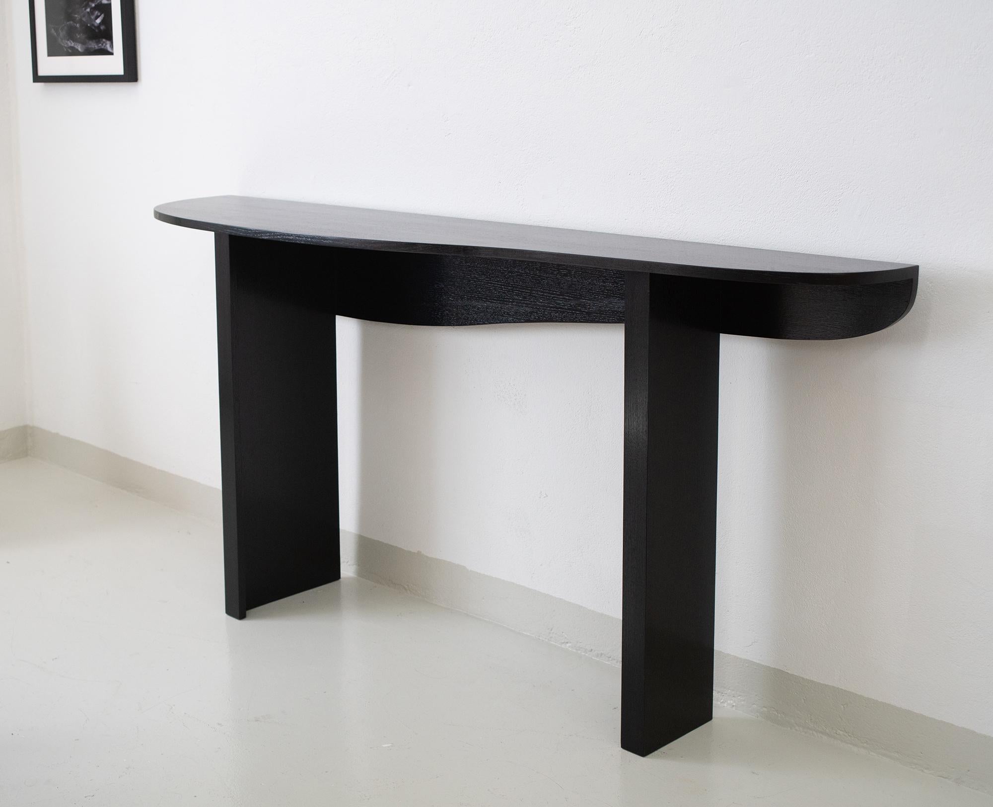 Long console in stained oak by Jacques Jarrige with a undulating top supported by straight legs. Customizable.