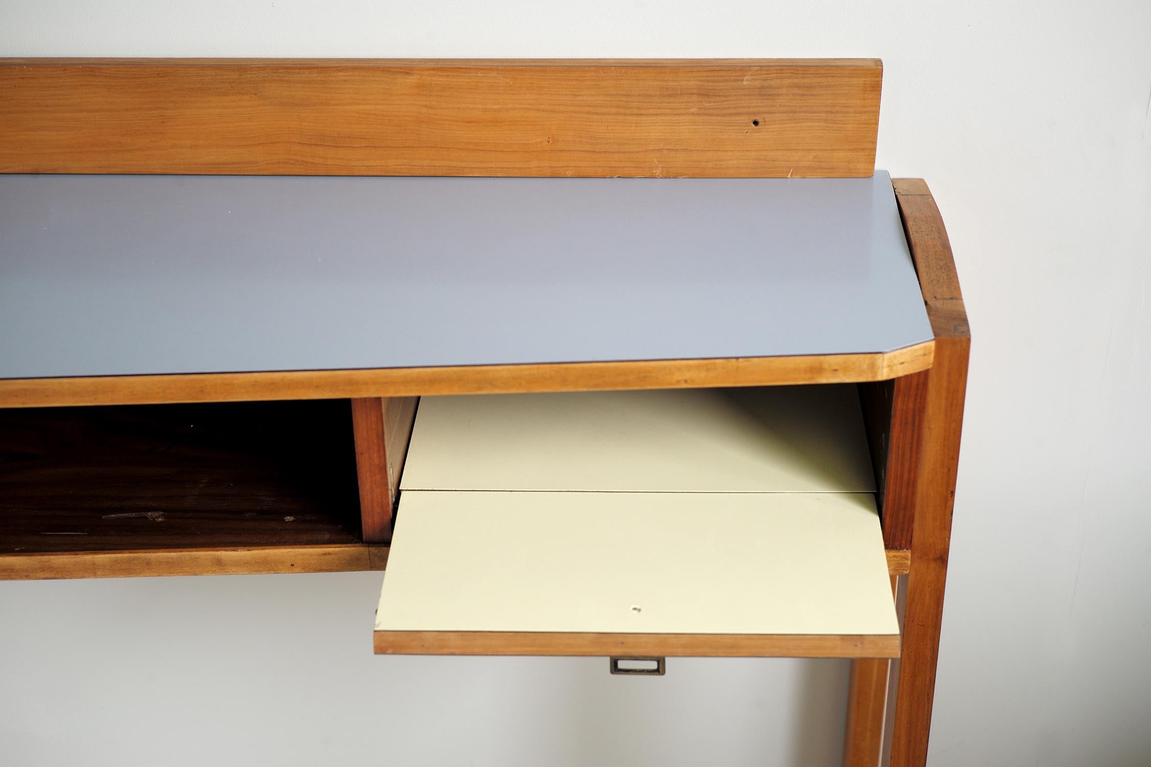 Large wall console in walnut and gray and yellow Formica, Italy, 1955.
The cradle base screwed on the sides reinforces the wall hook, (fixing holes in the interior niches). Topped with a plinth and fitted with a flap locker, this copy is one of the