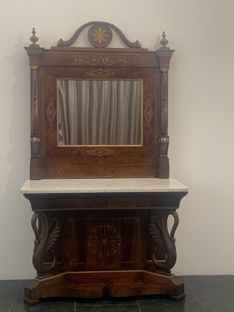 Prestigious console table with mirror in solid walnut and walnut panelling, on the front it has 2 finely carved swans, inlays and brass hardware. The top is in white marble. Excellent cabinet-making, period end '700/early '800. On the back still has