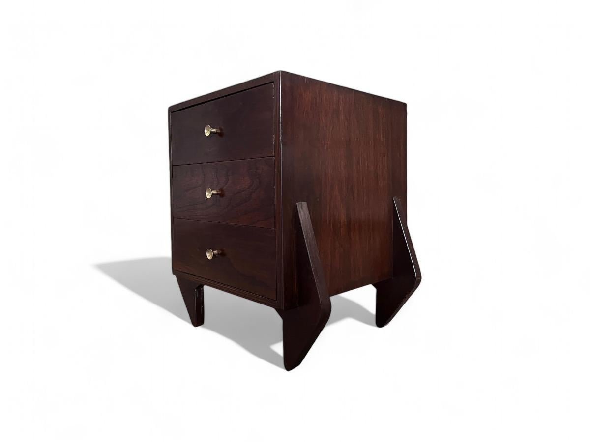 Cette rare console présente une structure carrée à quatre pieds et trois tiroirs en contreplaqué marine avec des poignées en laiton. Une pièce polyvalente comme celle-ci peut faire office de console ou de table de chevet. La pièce a été revernie et