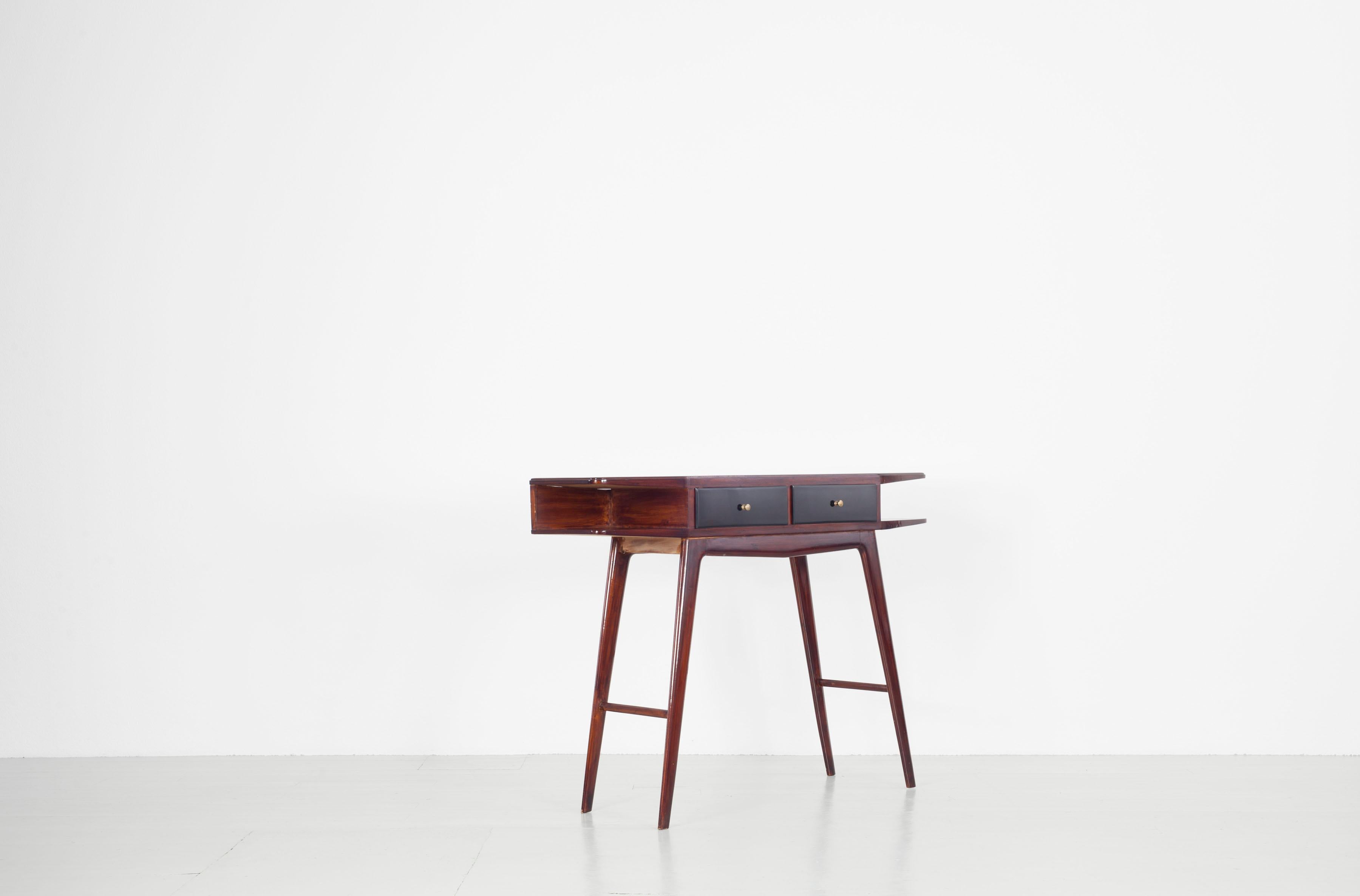 Console of palisander wood from the Italian, 1950s. The console in straight lined shapes owns two black lacquered drawers with brass handle and a black inserted glass plate.

  