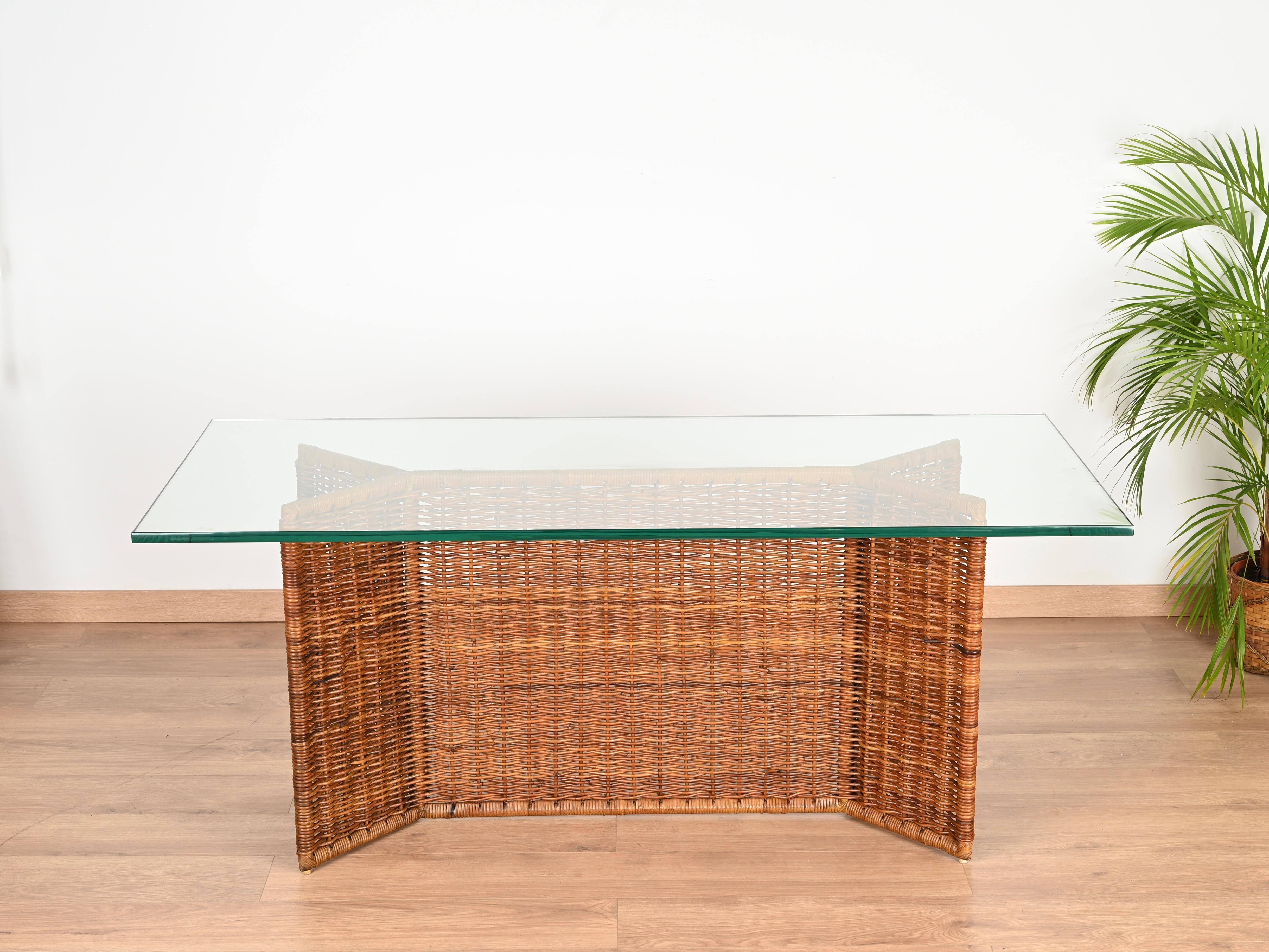 Stunning Italian console or dining table entirely made in hand-woven rattan wicker and completed by a fantastic 19 mm thick crystal top. This stylish piece was hand-made by Vivai del Sud in Italy during the 1970s.

In fabulous condition and with a