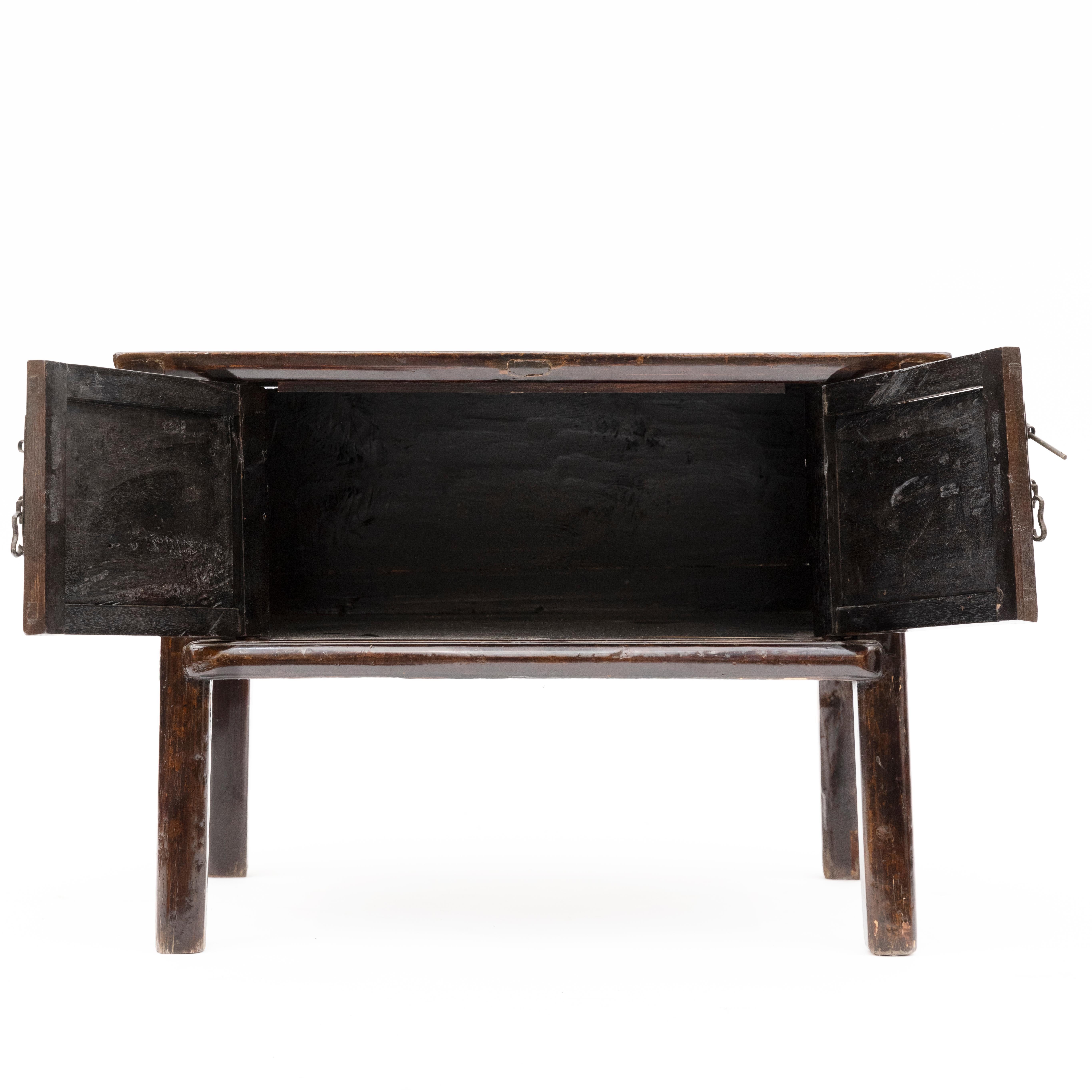 Console/ table d'appoint chinoise en bois d'orme, laquée d'origine en bordeaux foncé, présentant une patine naturelle liée à l'âge.
Portes à deux battants avec ferrures en laiton patiné.

Style Qing, province de Jiangsu, 1850-1870