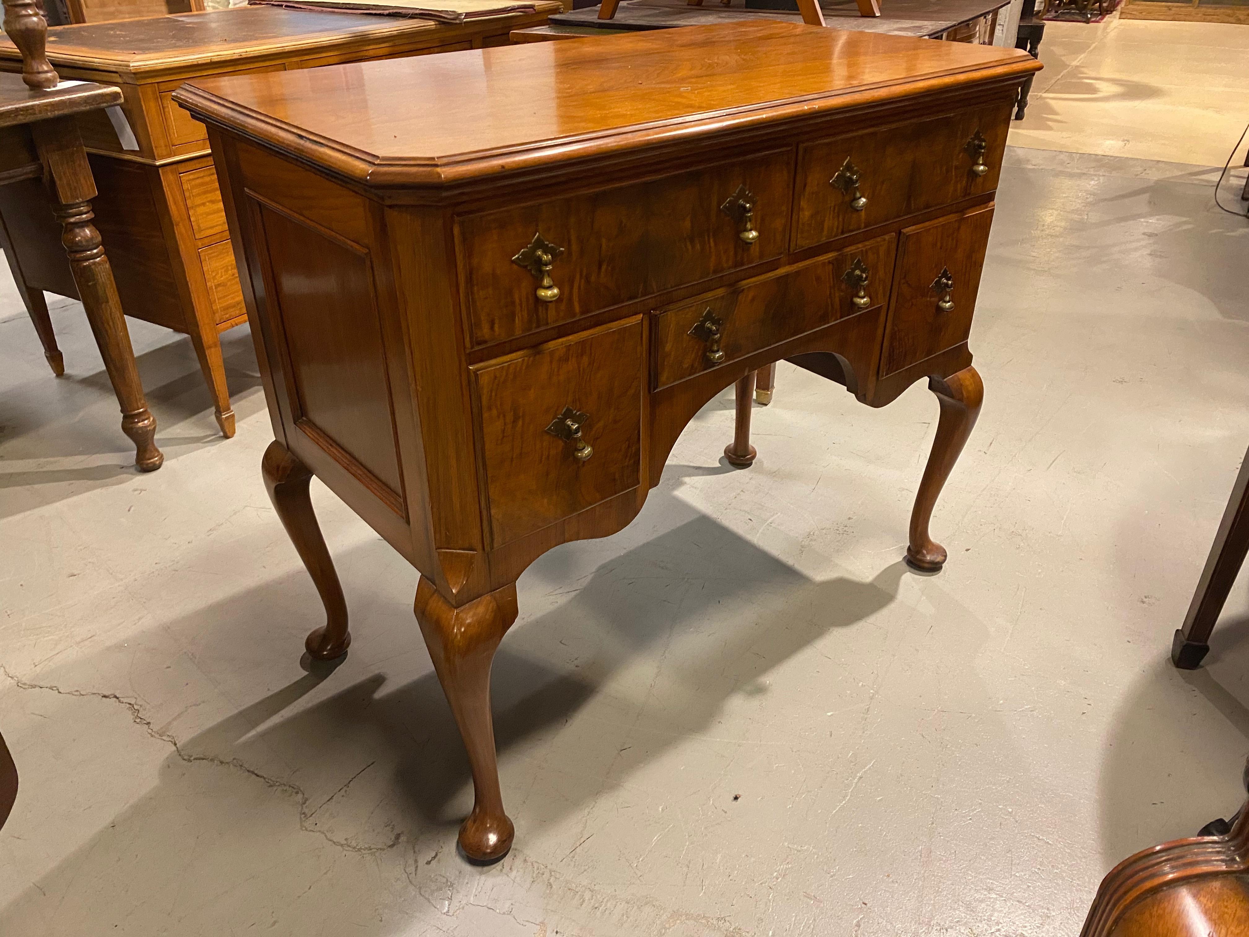 This is a handsome console serving cabinet with 5 drawers, walnut solids with burr walnut drawer faces.
This walnut commode or serving cabinet has 5 drawers, 2 large 3 small with brass drop handles in the period style.
You will notice the Burr