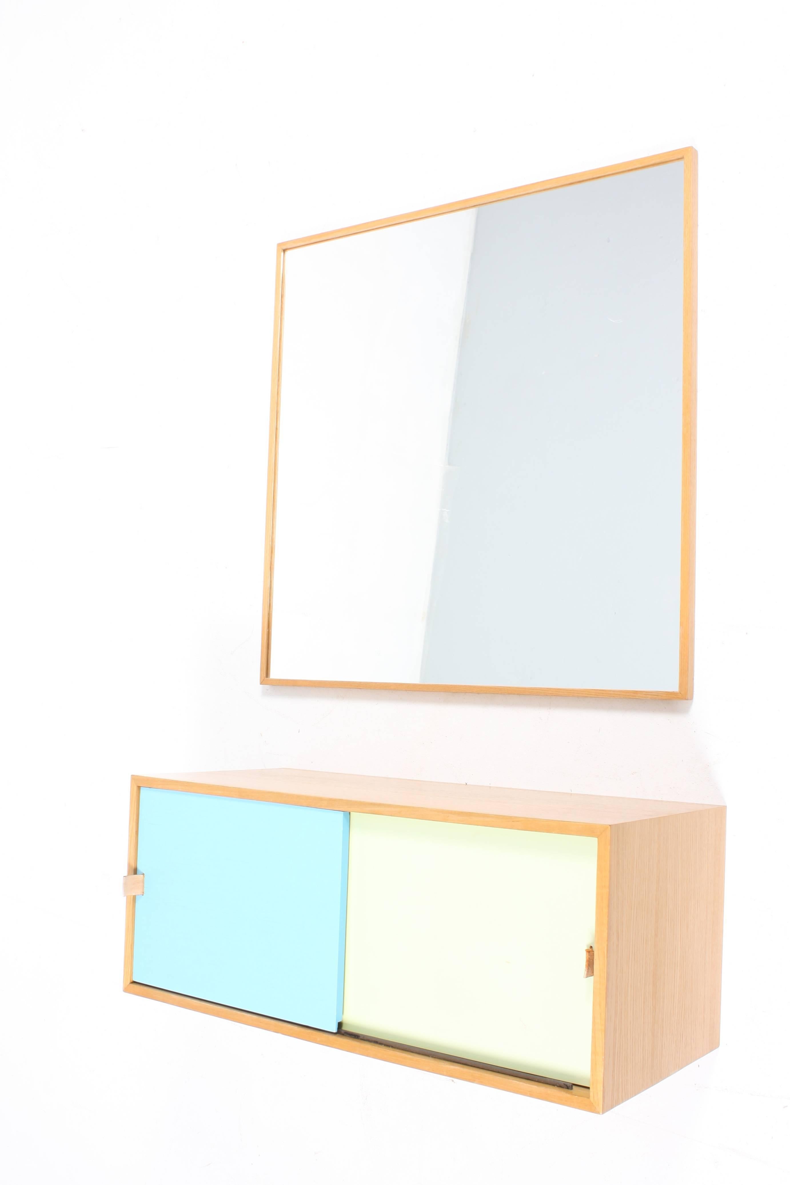 Matching mirror and console in oak with colored panels and handles in patinated leather. Designed and made by Harbo Sølvsten M.A.A in the 1950s. Made in Denmark. Great original condition.