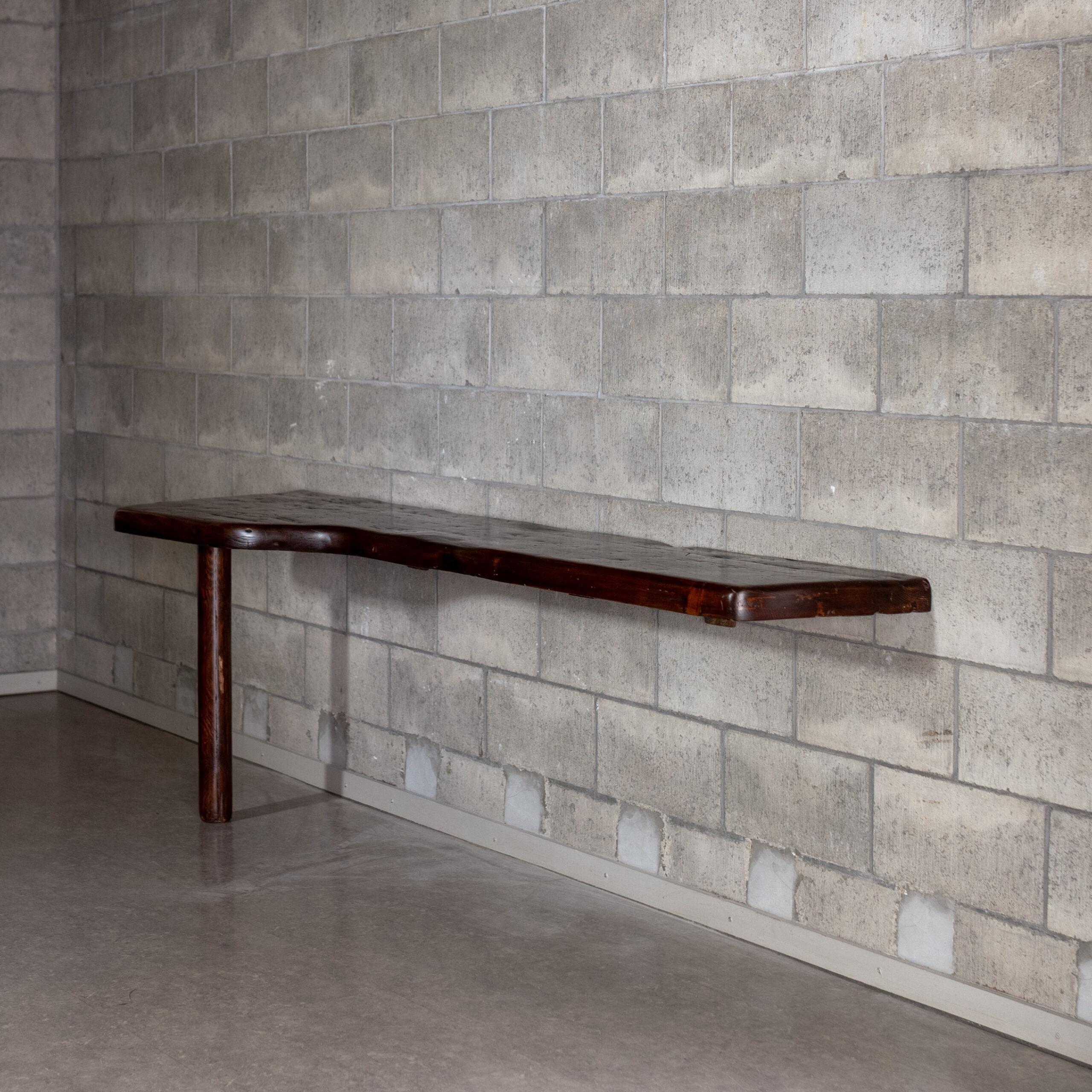 A console table designed by Charlotte Perriand. Carved from solid wood, its sculptural form and single cylindrical leg reflect Perriand’s unique approach between architecture and nature materials. Balance, material honesty, and spatial simplicity.