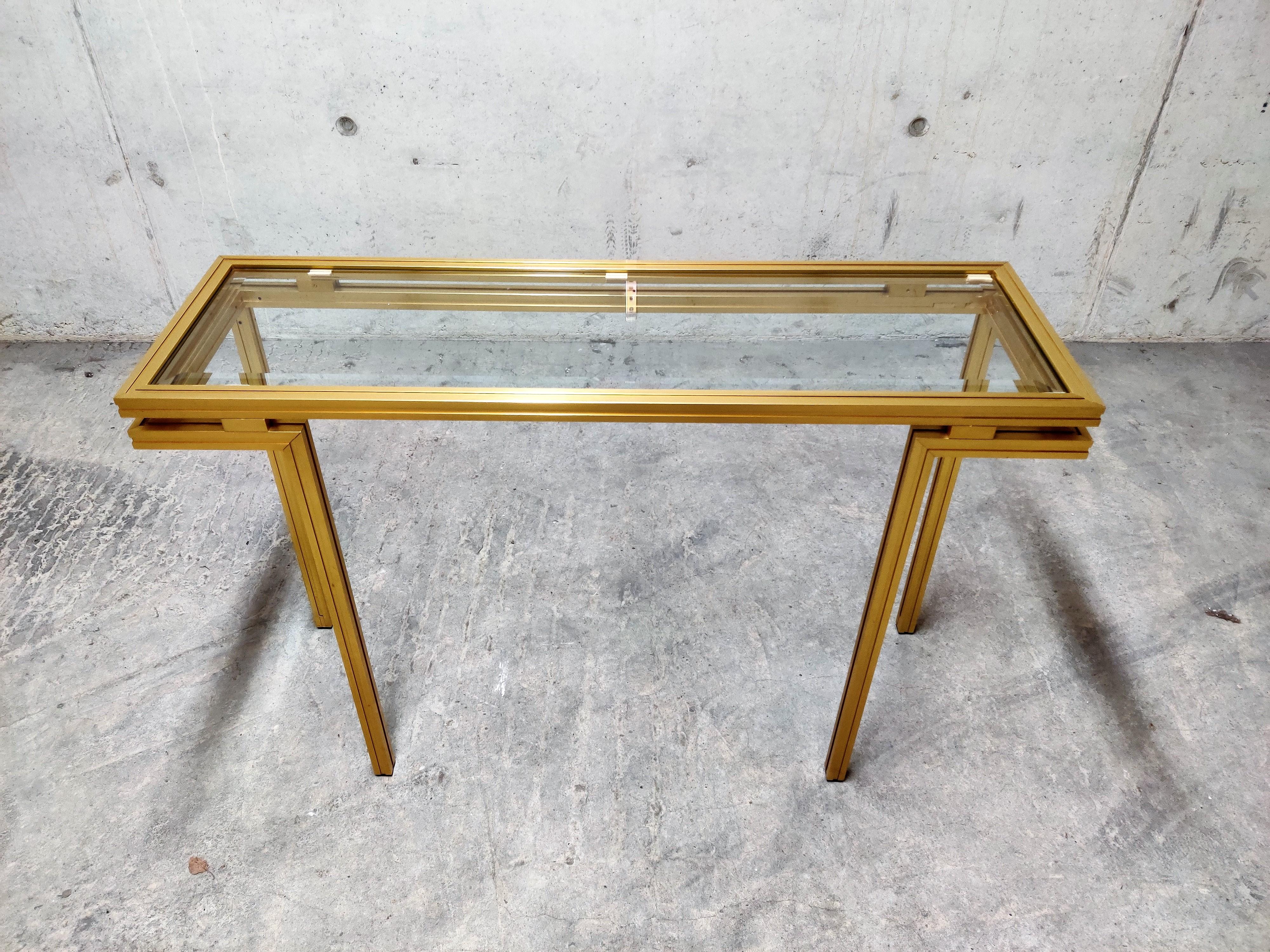 Vintage brass console table by Pierre Vandel.

This geometrical design console table has a clear beveled glass top.

Hollywood regency style.

Perfect condition.

1980s, France

Dimensions:
Height 74cm/29.13