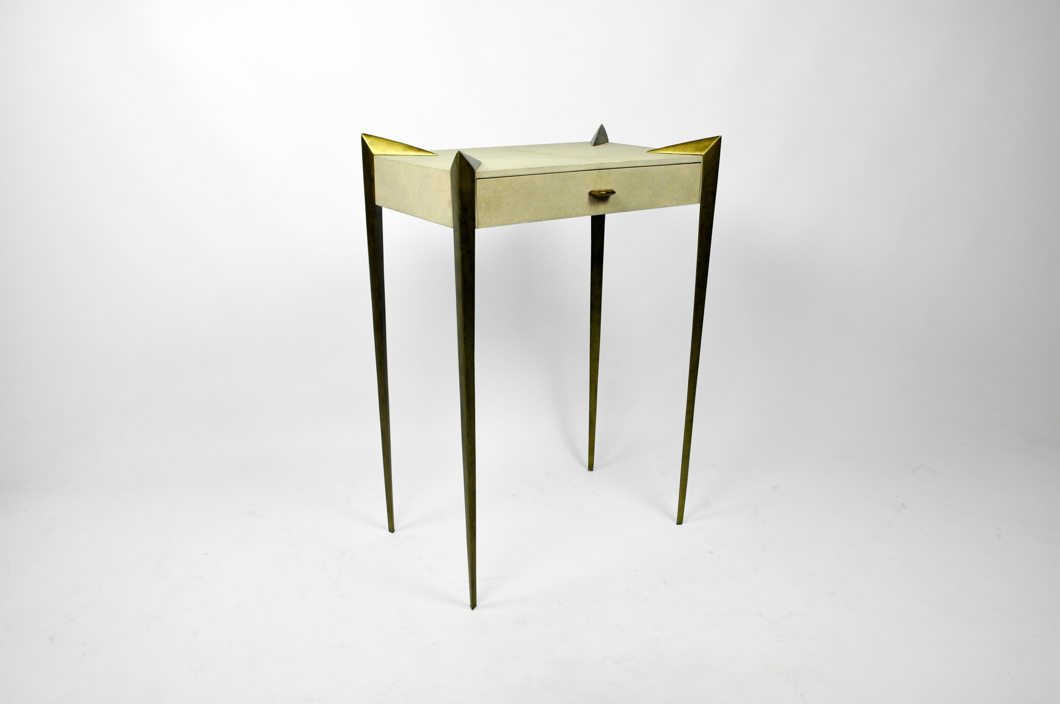 The side table Circini is made of shagreen.
 It has one thin drawer and the legs have an old brass patina.
This piece will settle very well in your entrance or your living room. The small dimensions make it very versatile for small or large