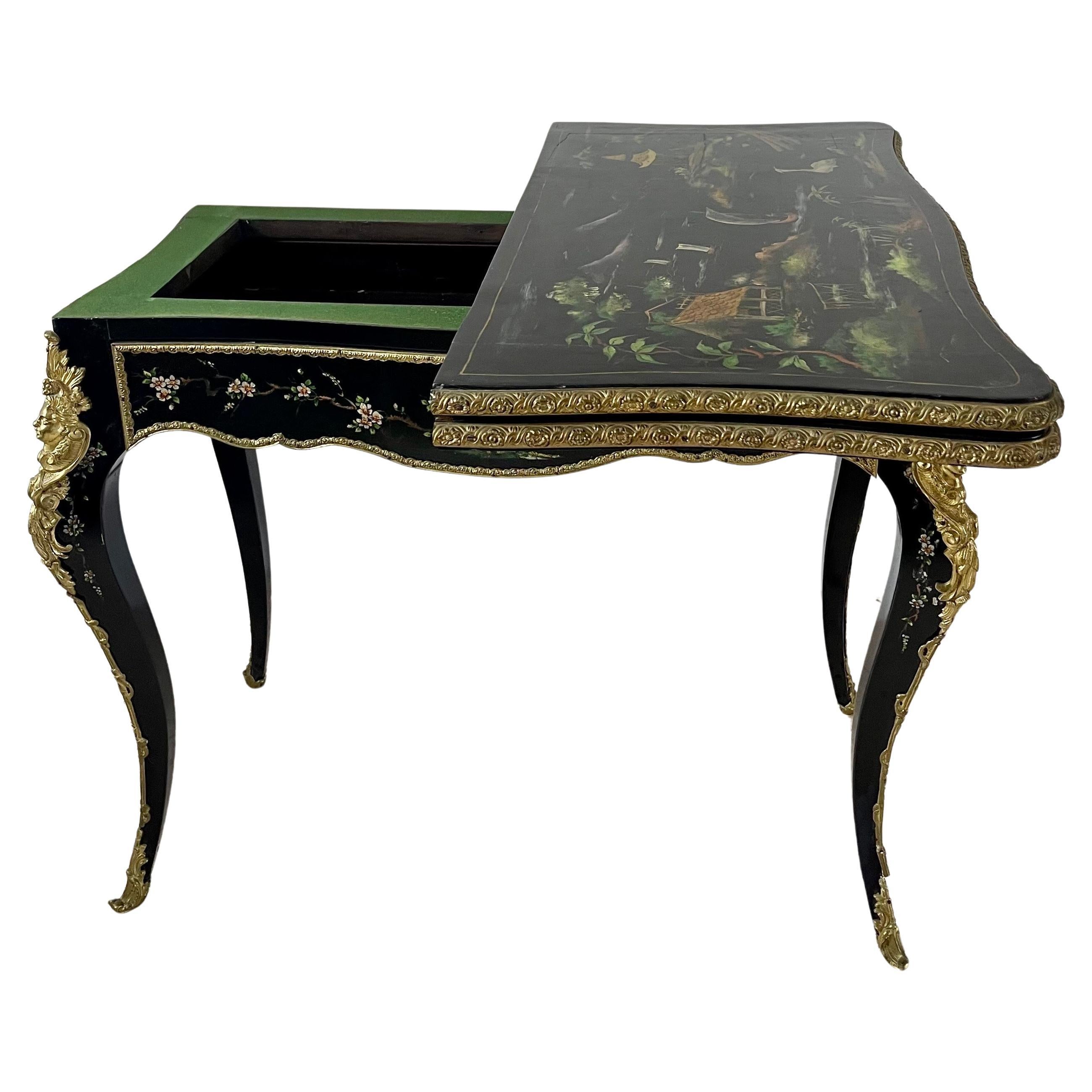 Console de table de jeu du 19e siècle, laquée noire et peinte de petites fleurs colorées.
Des ornements en bronze soulignent les bords de la table. Des personnages finement ciselés en bronze doré sont appliqués sur chaque pied cabriole.
Un tiroir à