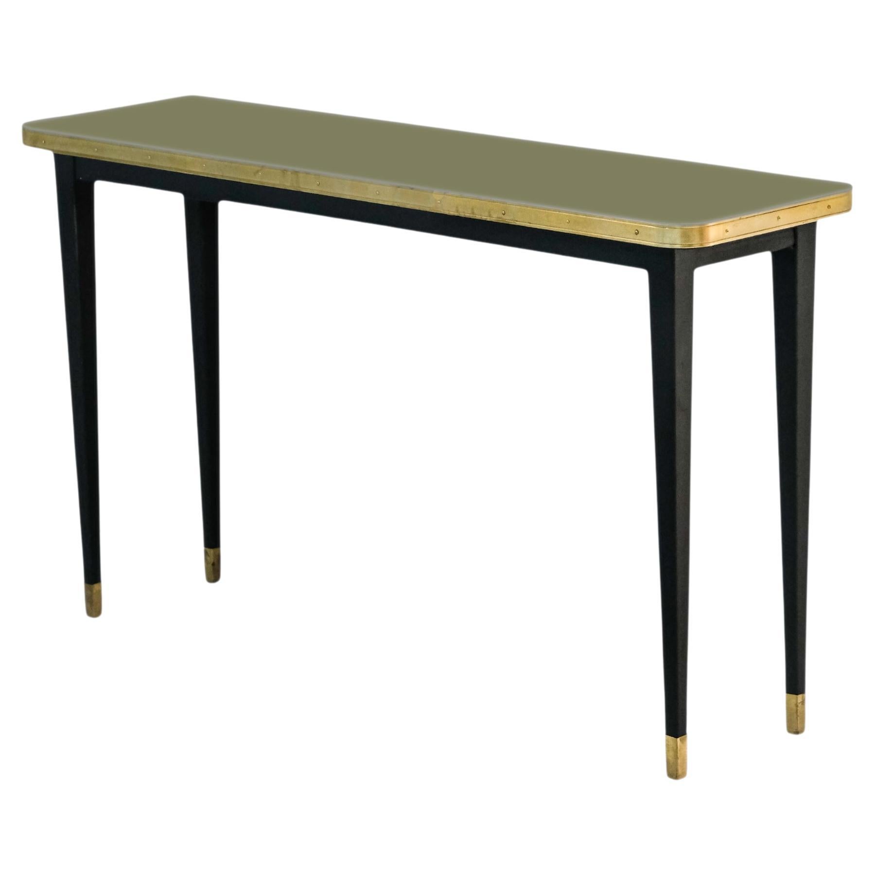 Collectional. 

Table console avec plateau brillant, encadrement en ruban de laiton, pieds coniques enrobés de poudre noire avec embout en laiton

Cette superbe table console en acier peint par poudrage noir est dotée de pieds coniques élégants et