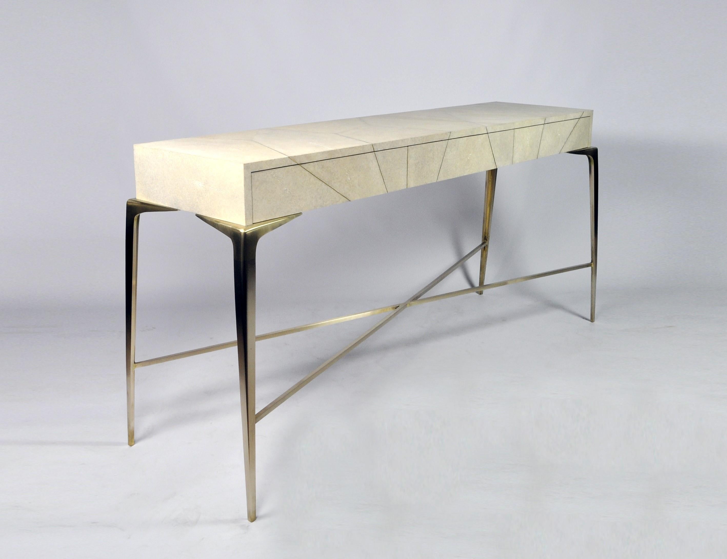 The console table Hydra is made of genuine shagreen with brass trims .
It has three drawers and the legs are made in solid brass with a brushed finishing.
The interior of the drawers are in light oak veneer.
This console will settle very well in