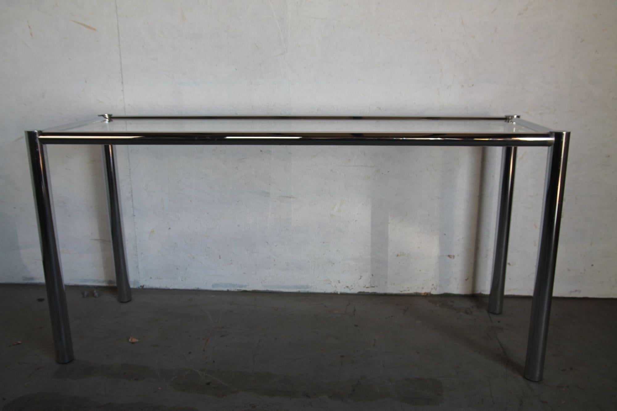 Simple chrome and glass console table in the manner of Milo Baughman. This table is in nice vintage condition with just some slight discoloration at the joints but that does not distract from the look of this table.