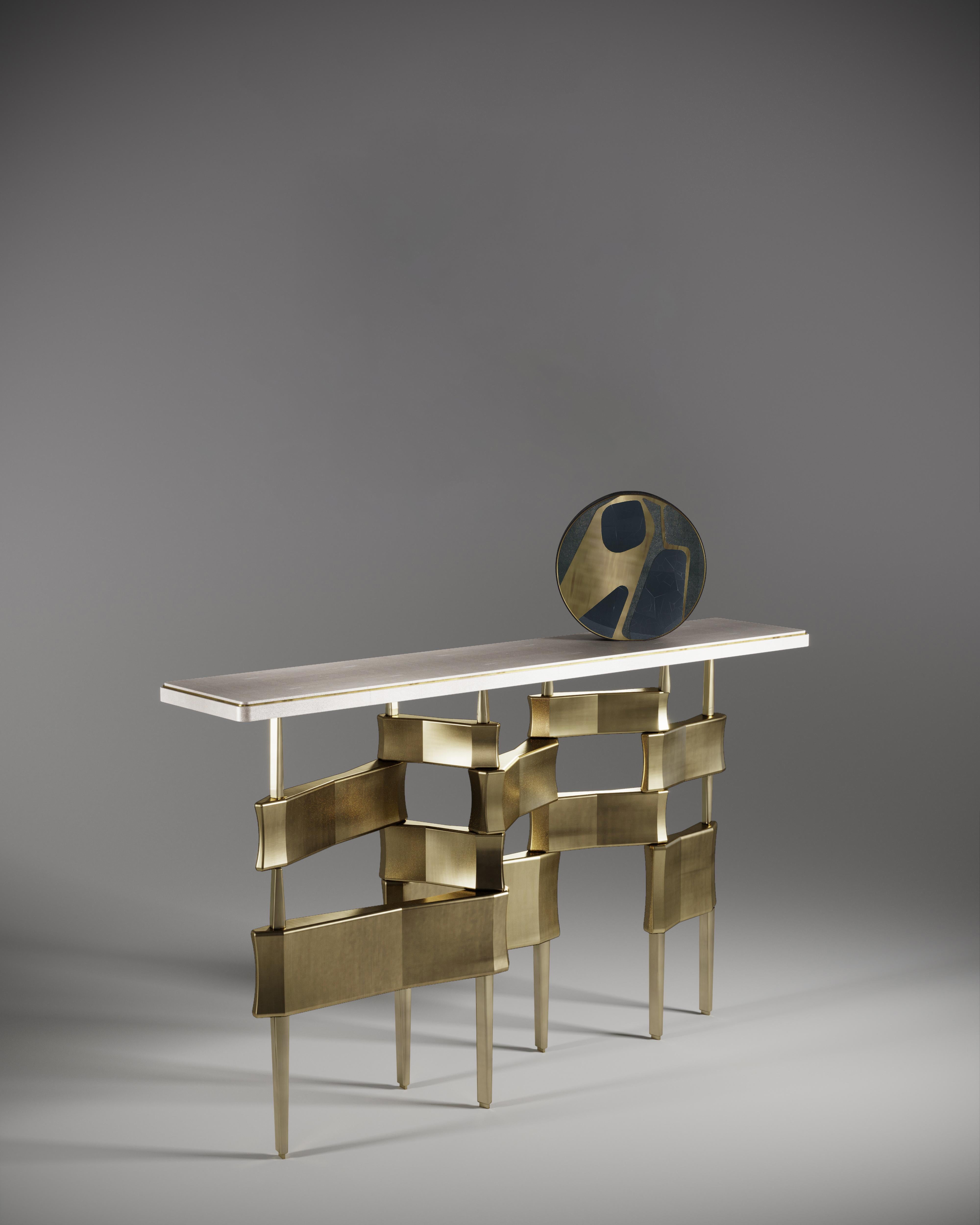 La table console Metropolis de Kifu Paris est un design dramatique et sculptural qui démontre l'incroyable travail artisanal et la signature de ses gènes Augousti. La base de la console, en laiton patiné, s'inspire conceptuellement de la ligne