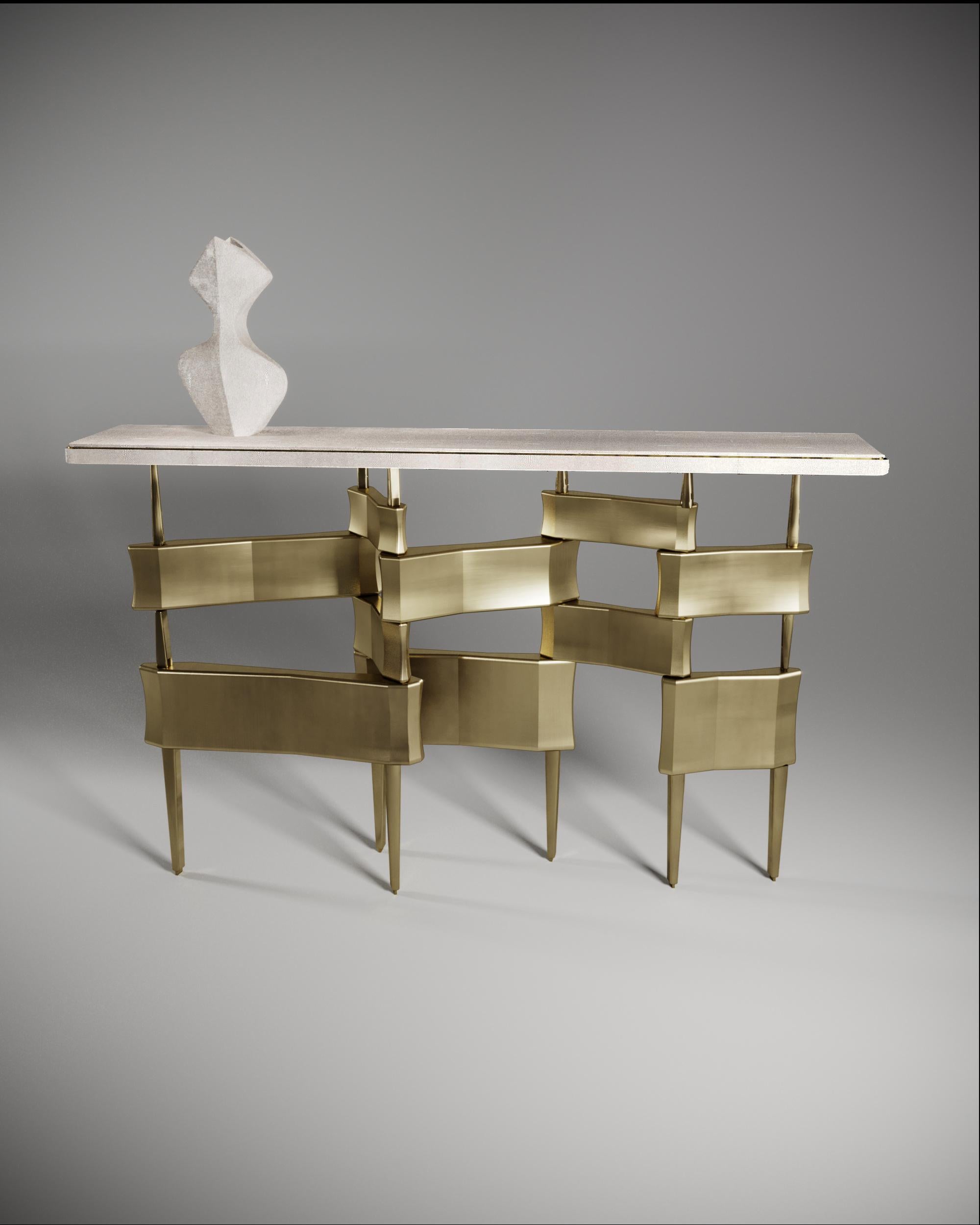 La table console Metropolis de Kifu Paris est un design dramatique et sculptural qui démontre l'incroyable travail artisanal et la signature de ses gènes Augousti. La base de la console, en laiton patiné, s'inspire conceptuellement de la ligne