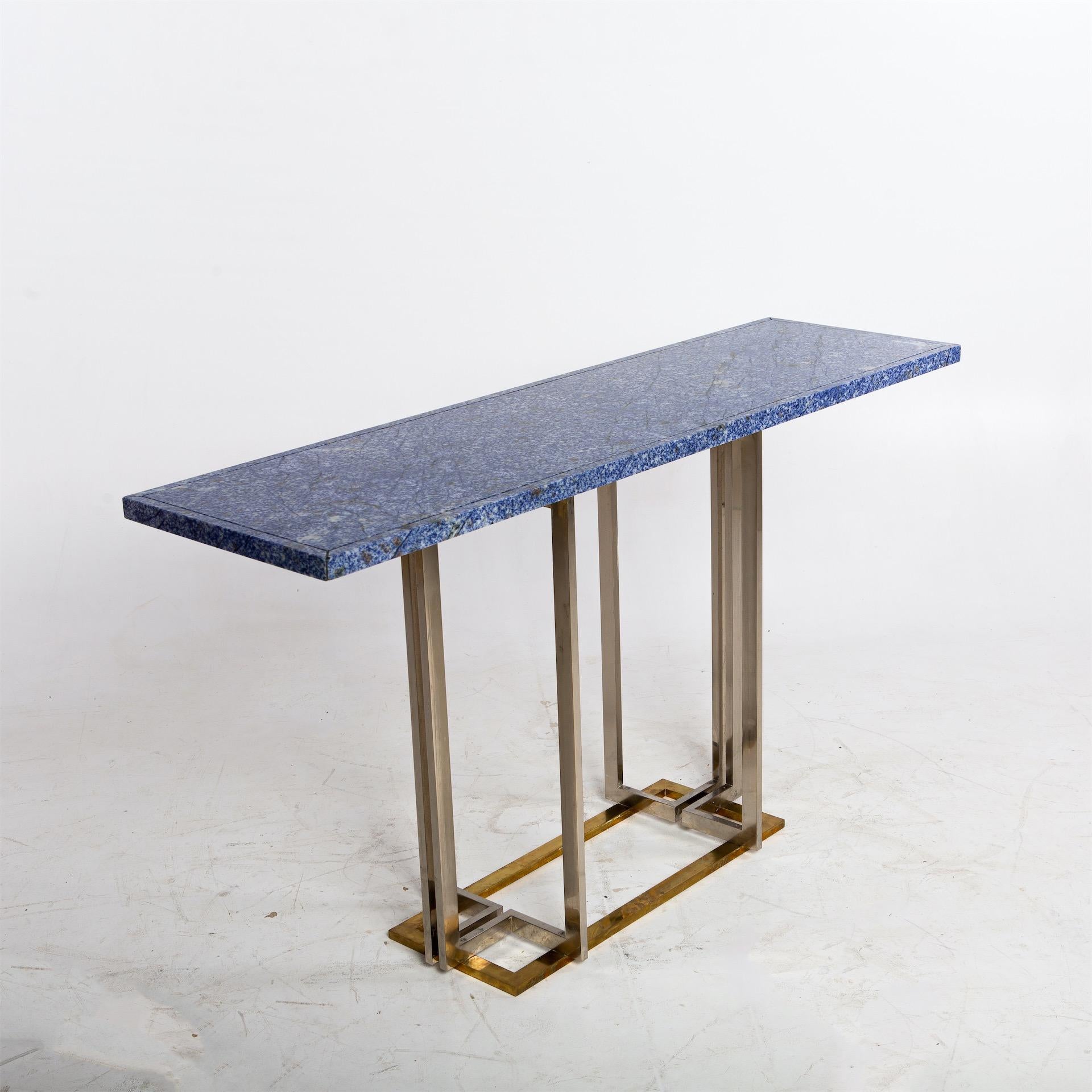 Wall console with blue stone plate standing on a chromed and brass-plated steel frame.
  