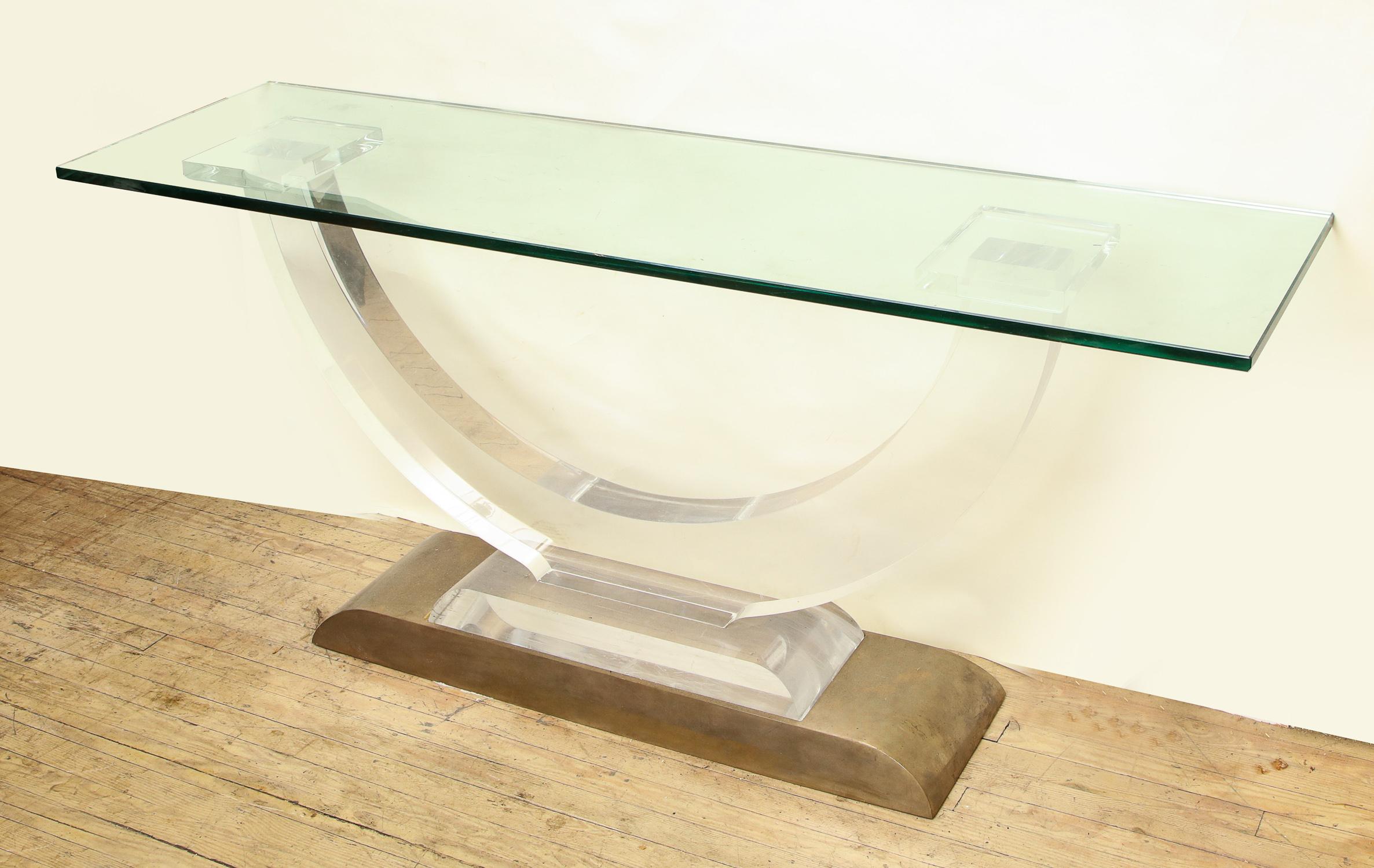 An Architectural console table Lucite and glass with a heavy brass base, 1970s.