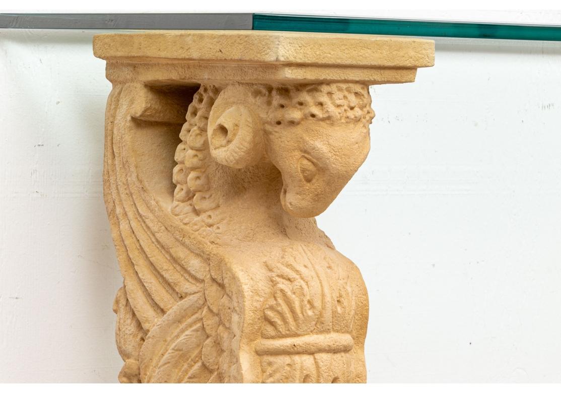 A highly decorative Console Table With twin composition Roman style sphinxes in a pale tan tone, with ram's heads and winged lion form bodies. They stand on plinths with acanthus leaves and recessed panels. With a fine thigh and full beveled green
