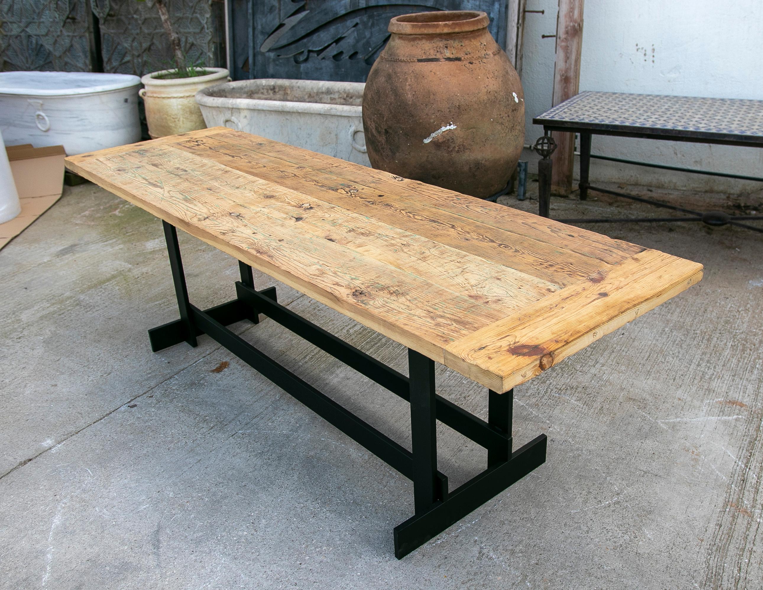 Table console avec base en fer et plateau en bois rustique.